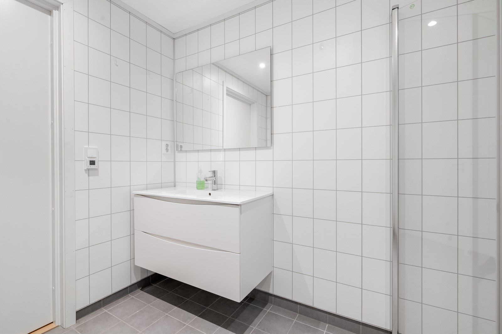 Her er det en stilren innredning med dype skuffer og heldekkende servant, samt speil på vegg. Galleribilde