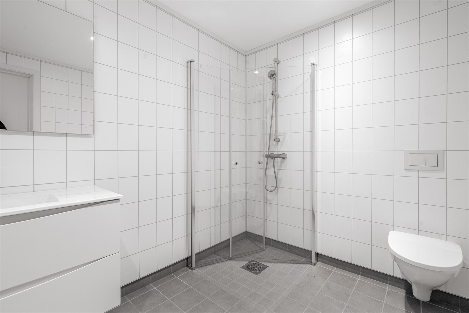 I dusjhjørnet er det plassbesparende, innfellbare glassvegger, og badet har veggmontert toalett. Down-light belysning i tak. Galleribilde