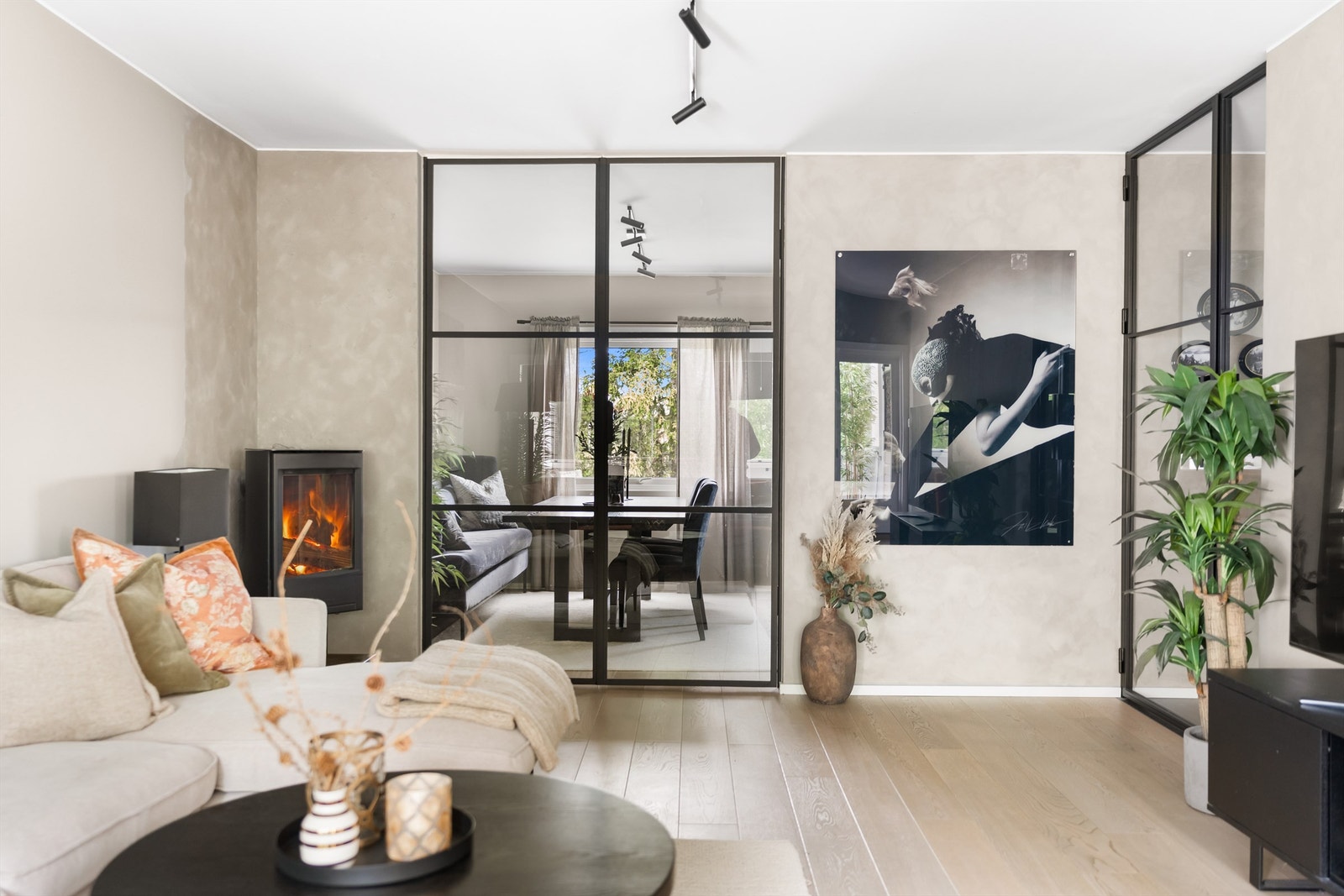 Romslig stue med gode møbleringsmuligheter. Legg merke til de tøffe glassdørene innrammet i smijern og moderne vedovn i stuehjørnet. Galleribilde