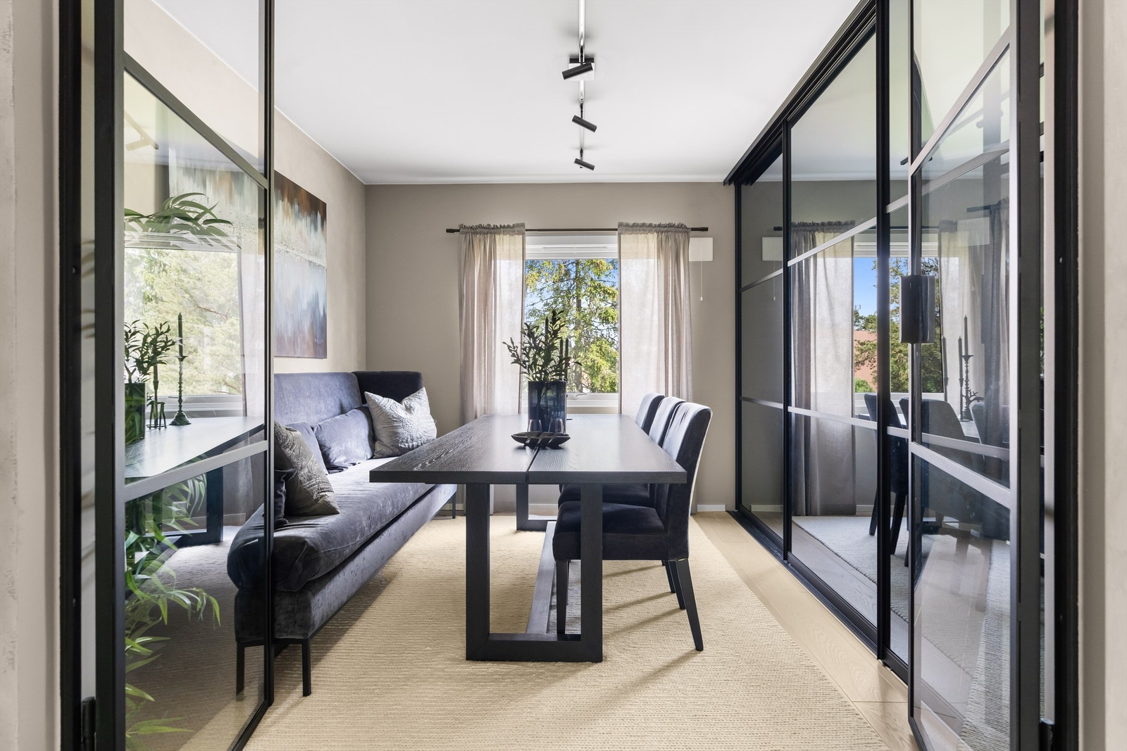 Nydelig spisestue med et smykke av noen stilige smijernsdører som sørger for det gjennomgående og fine lyset. Galleribilde