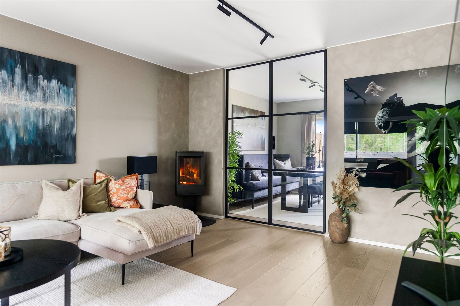 Stilig stue, med tøff og moderne detalj som trendy glassdører mellom soverom og stue. Galleribilde