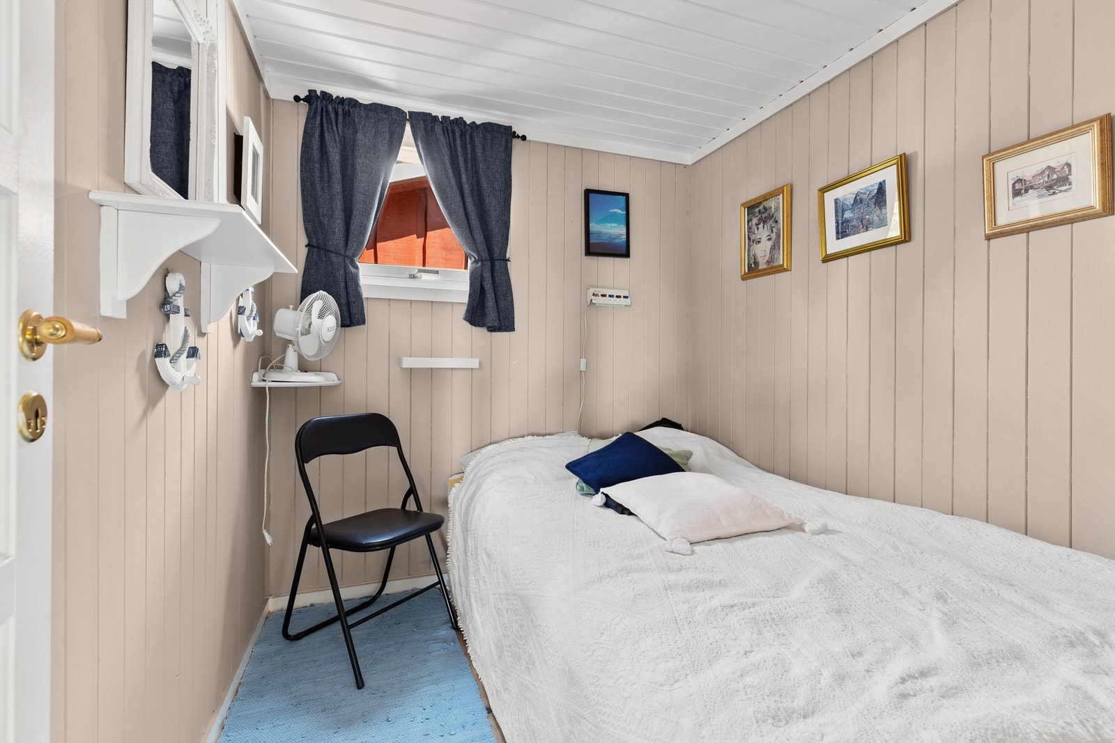 Soverom 2 med trebord på gulv, malt panel på vegger og malt panel i himling Galleribilde