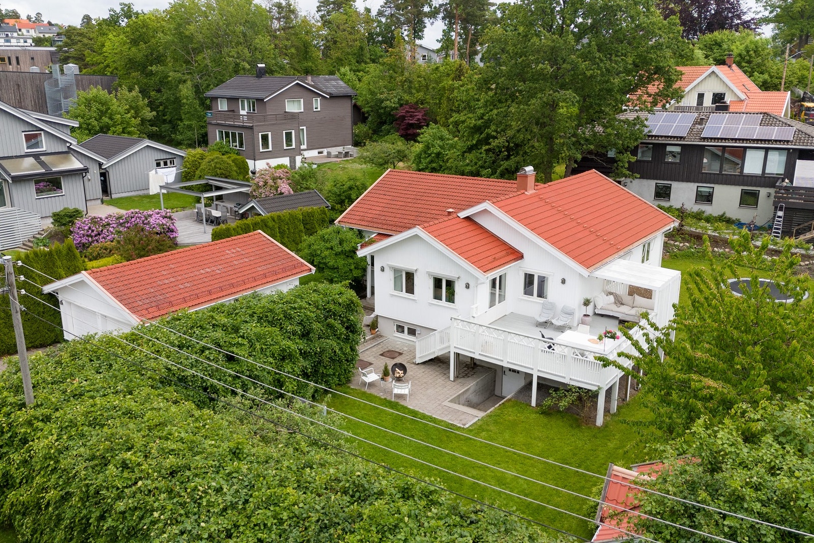 Tomten omkranses av frodig hekk som gir en lun og skjermet atmosfære Galleribilde