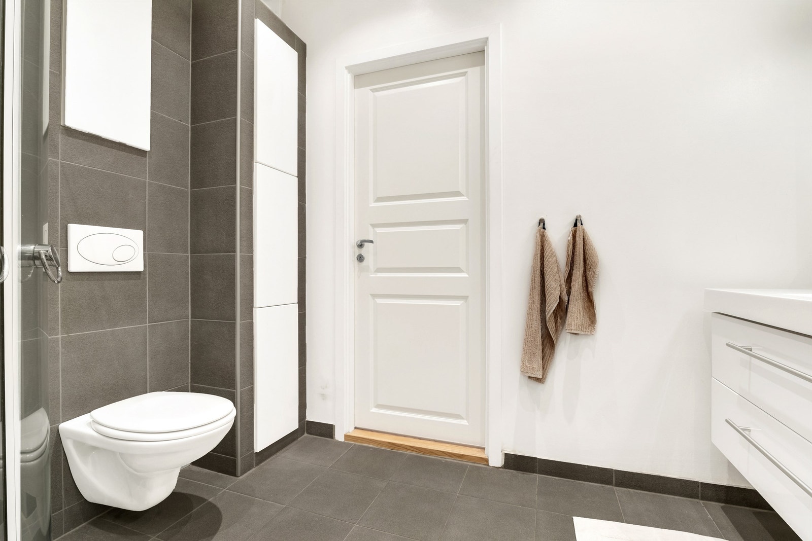 Badet er delvis fliset, med fliser på gulv og på vegg i sone med dusj og wc. Ellers er veggene malte flater. Galleribilde