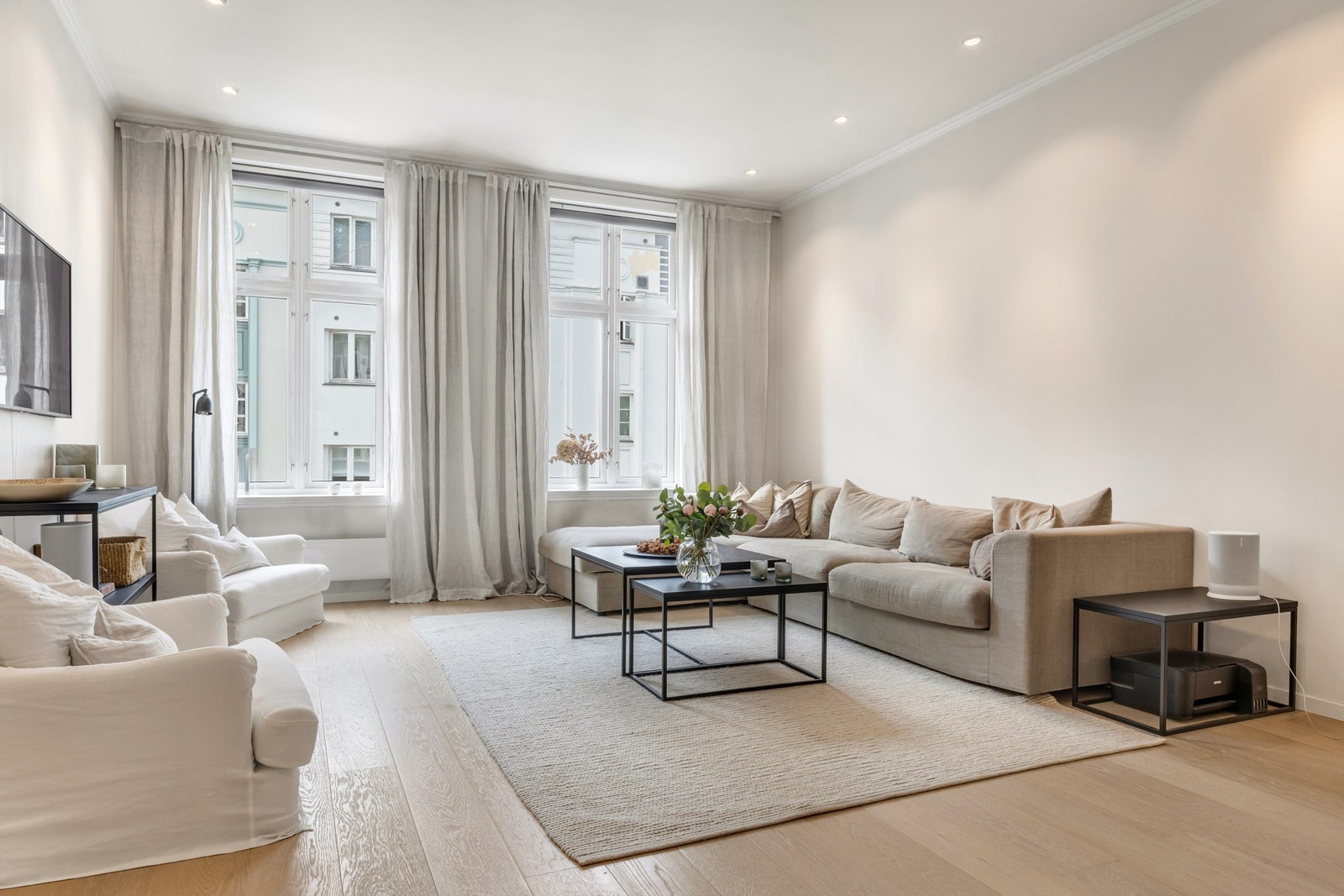 Lys og romslig stue med store vinduer som slipper inn rikelig med dagslys Galleribilde