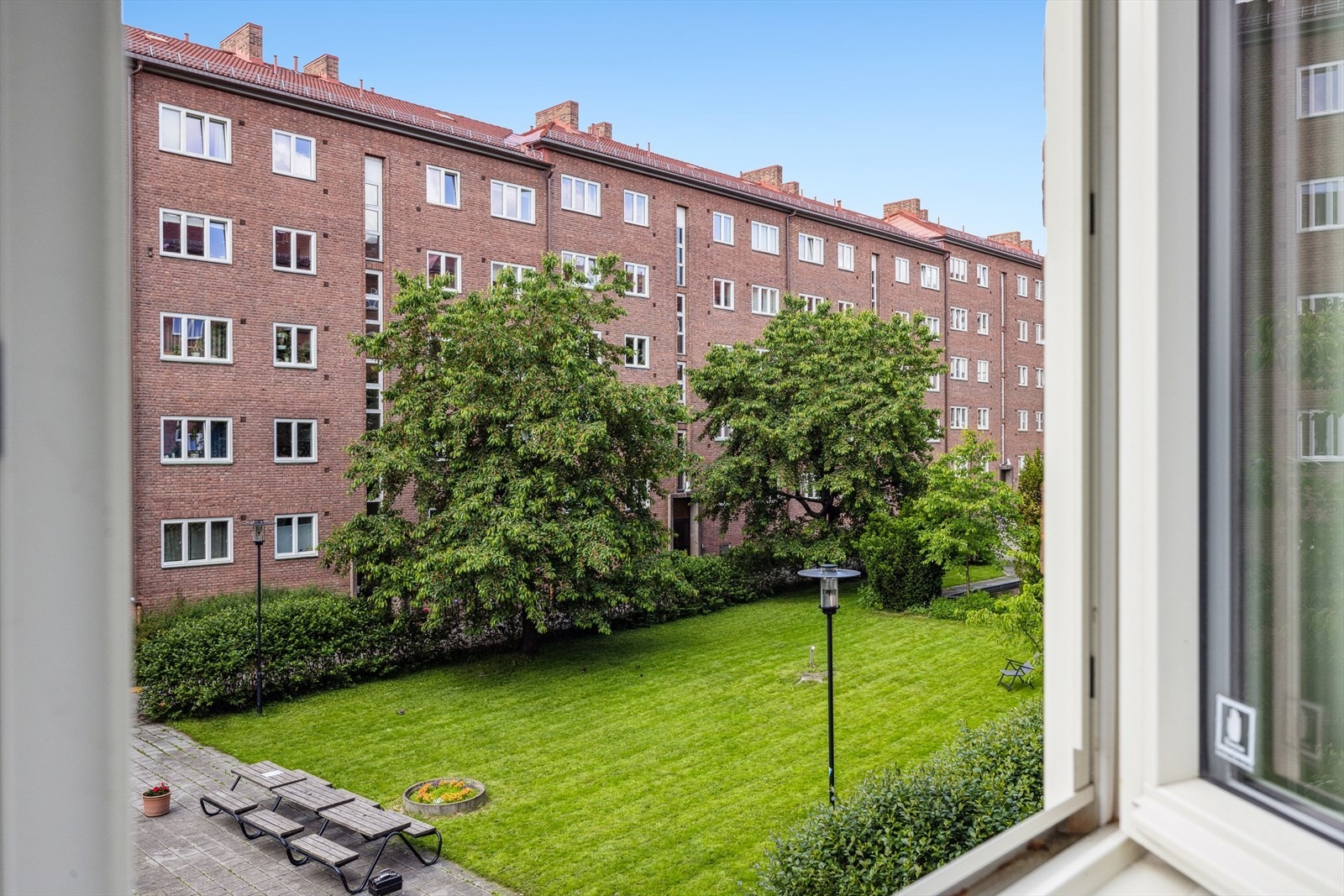 Utsikt fra kjøkken mot lukket og frodig bakgård Galleribilde