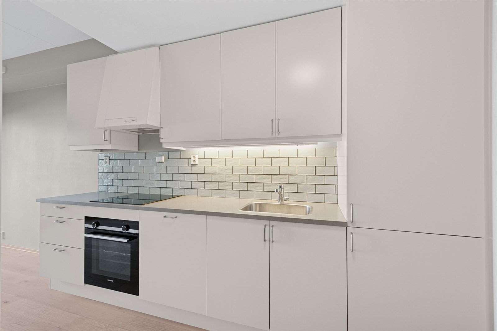 Hvitevarer som komfyr, koketopp, kjøleskap og oppvaskmaskin er integrert i innredningen. Galleribilde