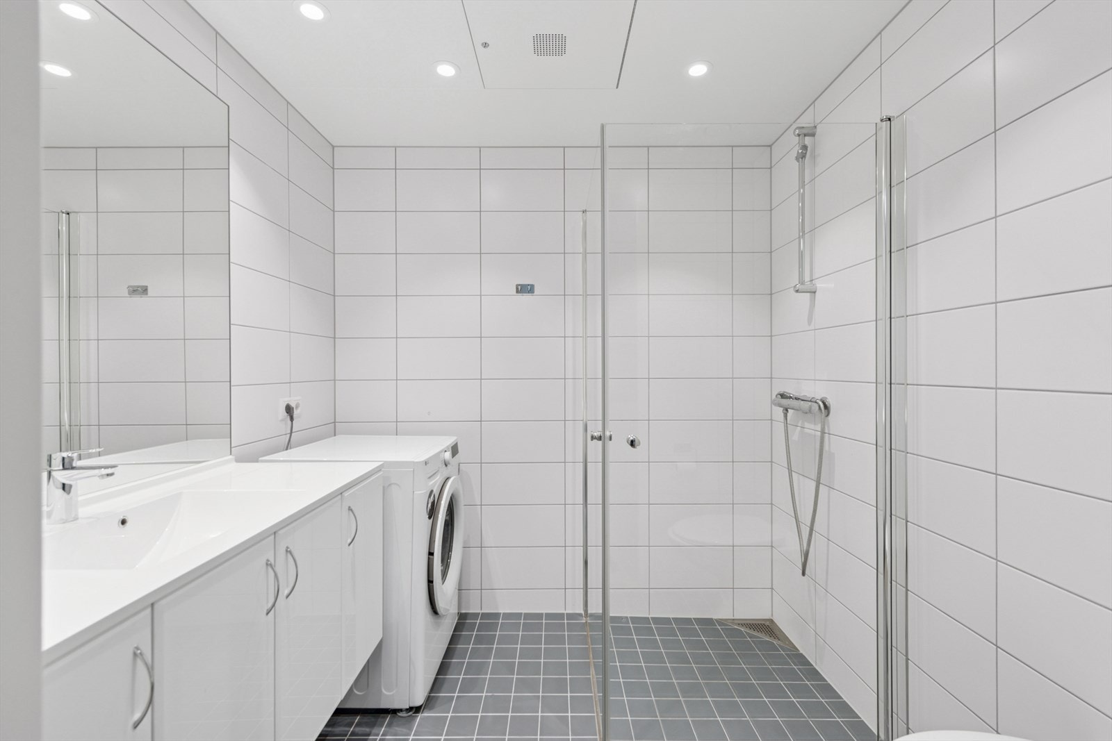 Flislagt prefabrikkert baderomskabin fra 2018 med gulvvarme og downlights i himling. Galleribilde