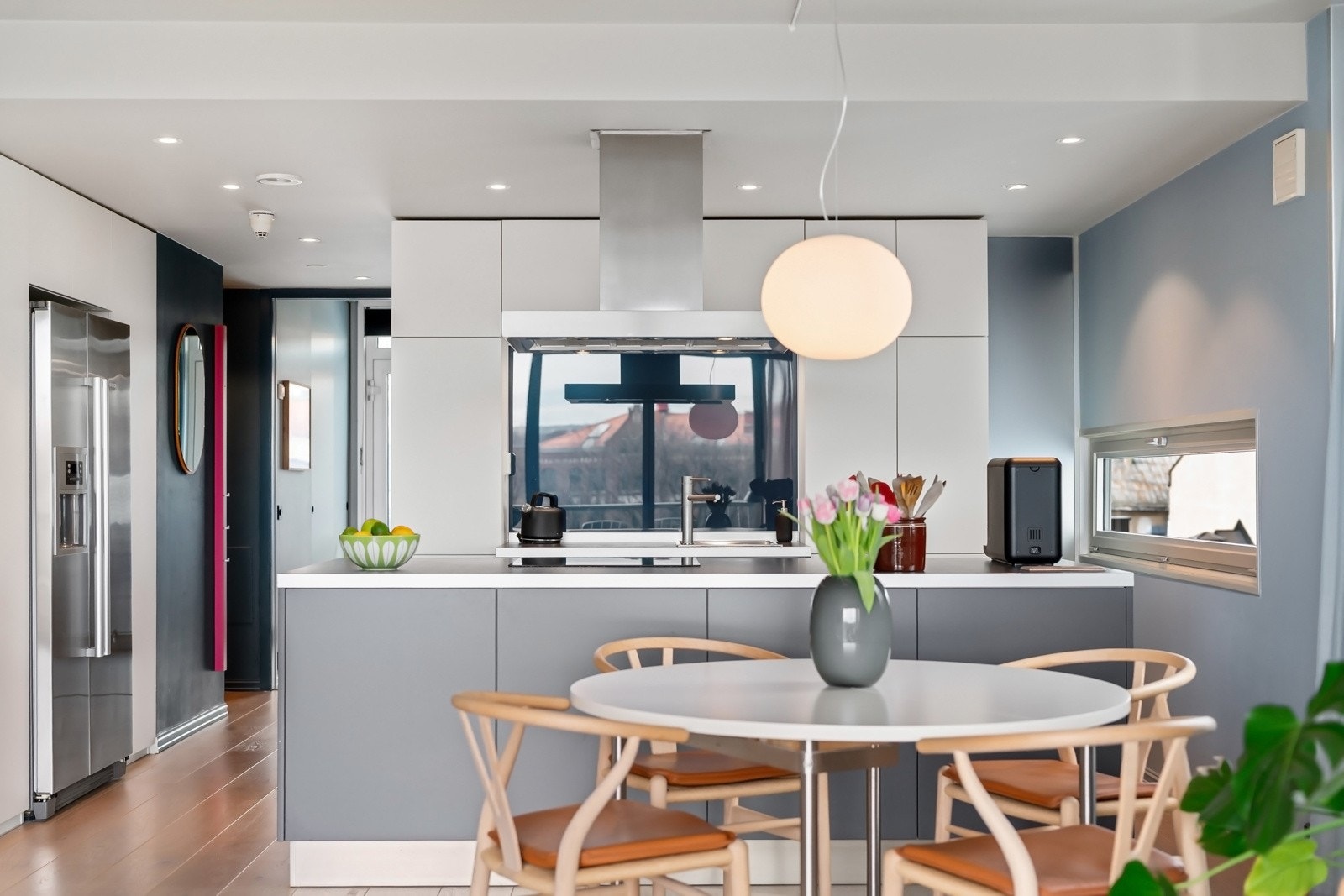 Innholdsrikt kjøkken med oppbevaring på begge sider av kjøkkenøyen. Galleribilde