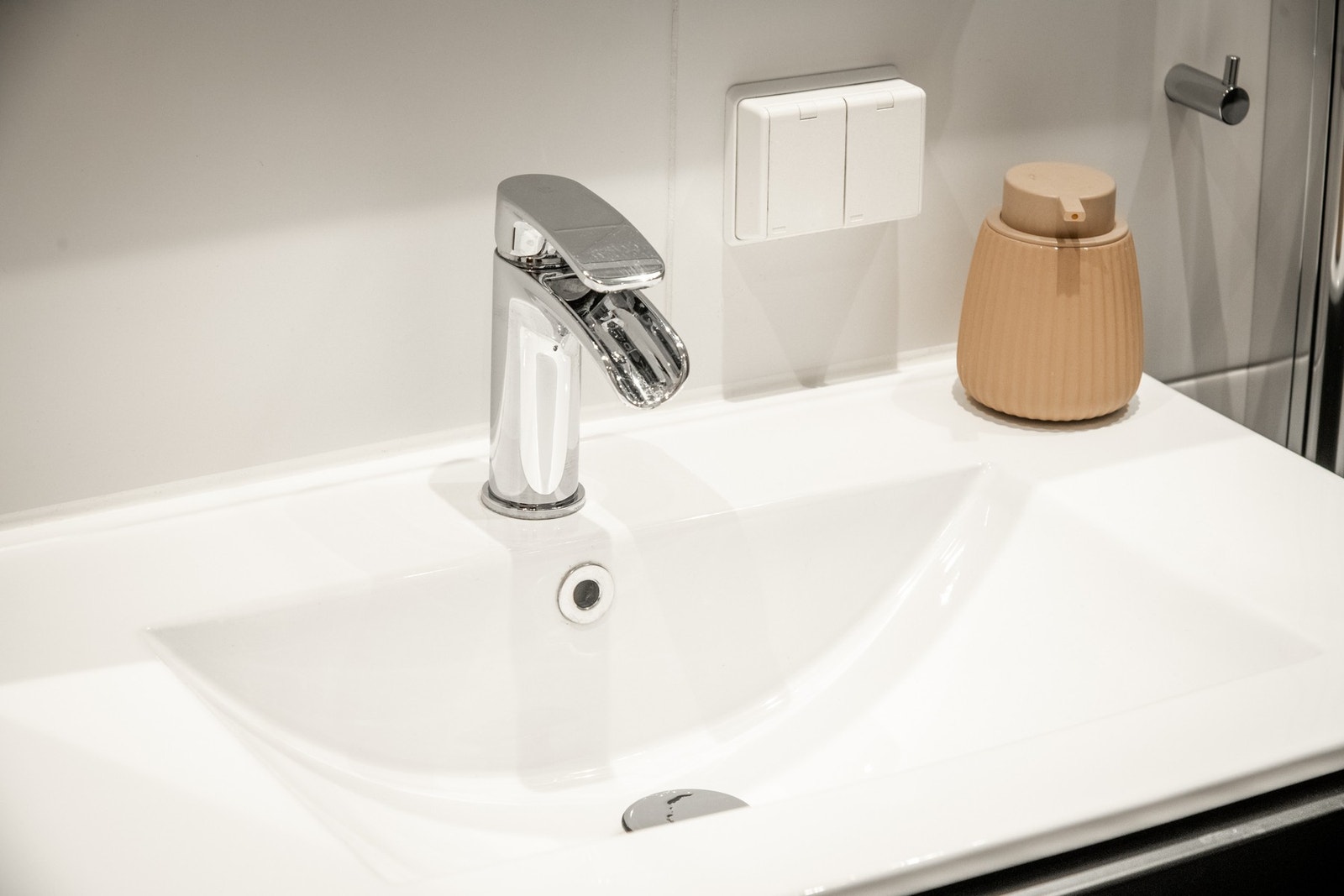 Innredningen består av en veggmontert skuffeseksjon med heldekkende servant, høye skap og speil. Galleribilde