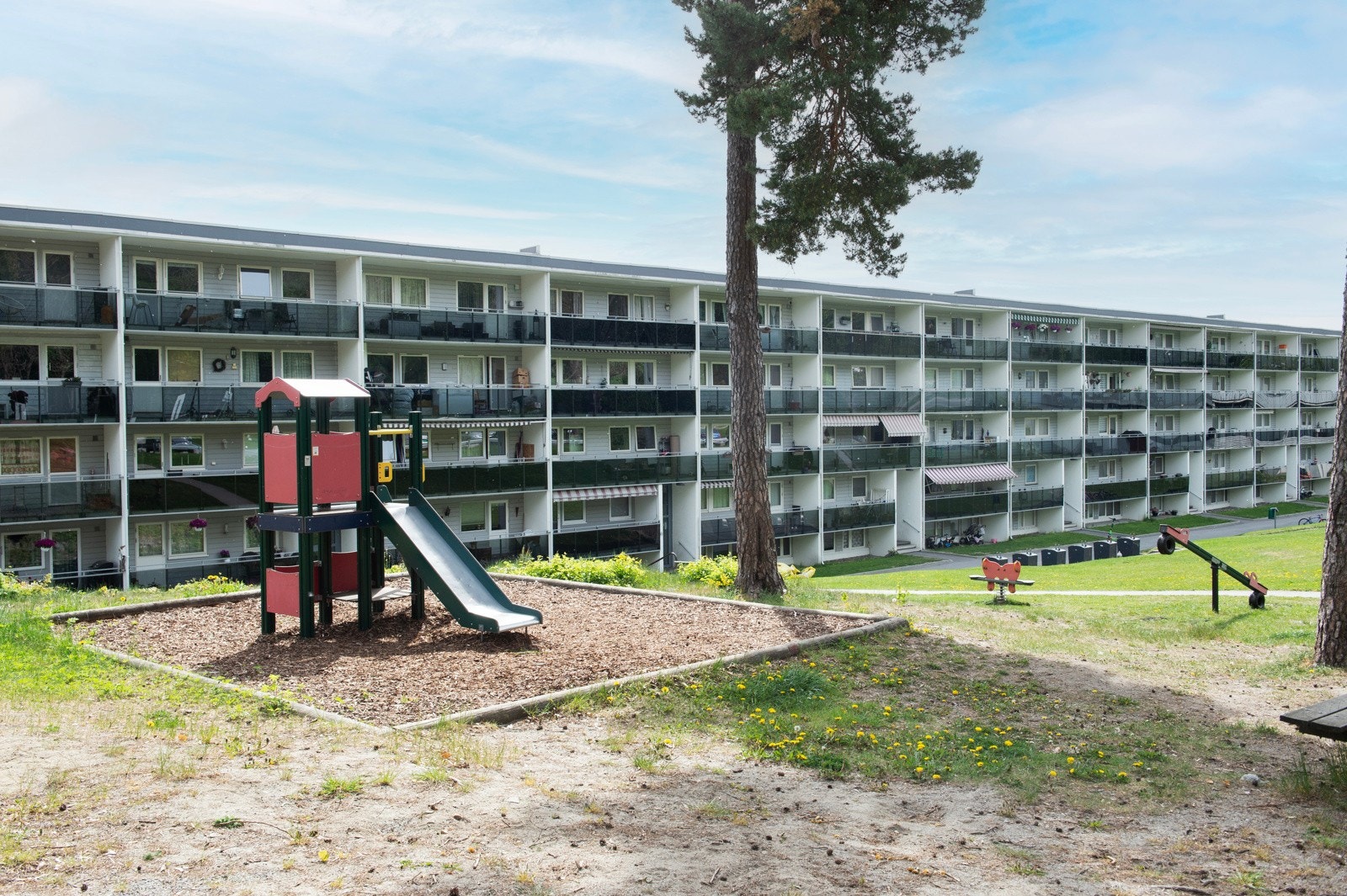 Fellesområder med lekeplass, sykkel- og bilparkering. Galleribilde