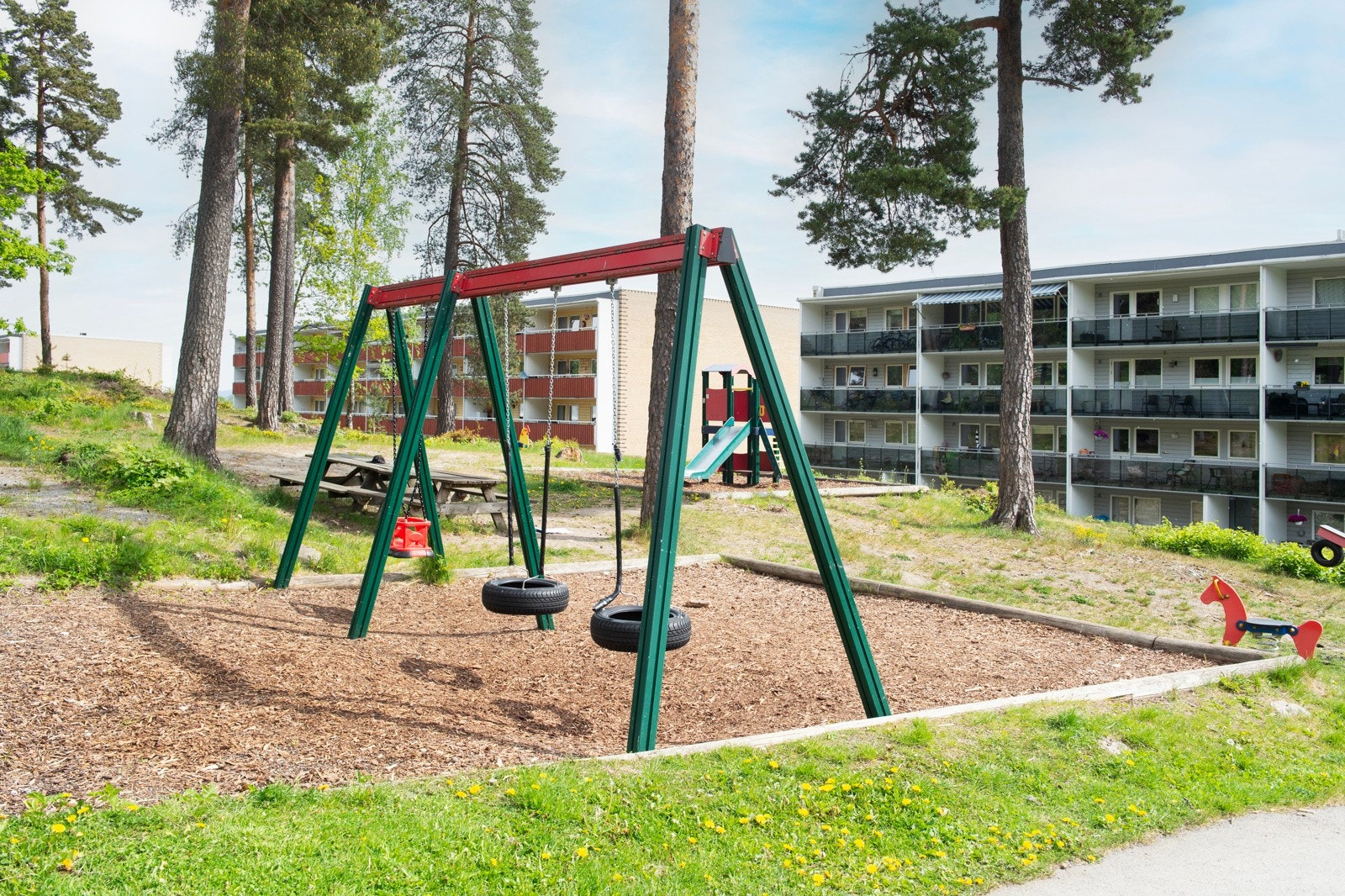 Fellesområder med lekeplass, sykkel- og bilparkering. Galleribilde