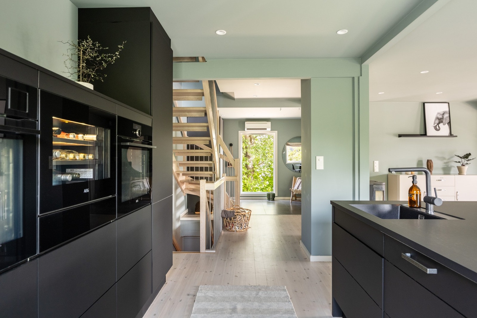 To ovner, platetopp, kjøleskap, vinskap og oppvaskmaskin er integrert i innredningen. Galleribilde