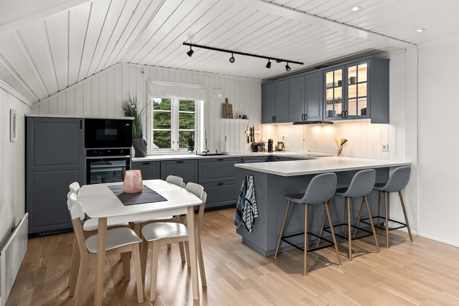 Godt tilpasset kjøkkenløsning med integrert stekeovn, platetopp, mikrobølgeovn, oppvaskmaskin og kjøleskap med liten fryser Galleribilde