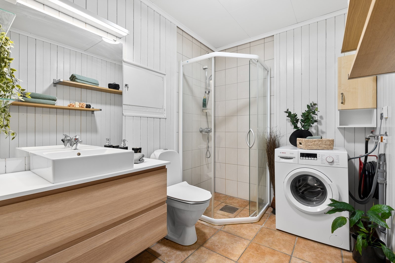 Badet har fliser på gulv med varmekabler, samt fliser i dusjsonen. Nåværende eier har satt inn ny baderomsinnredning med speil over. Forøvrig inneholder badet et toalett, dusjnisje, samt avsatt plass til vaskemaskin. Galleribilde