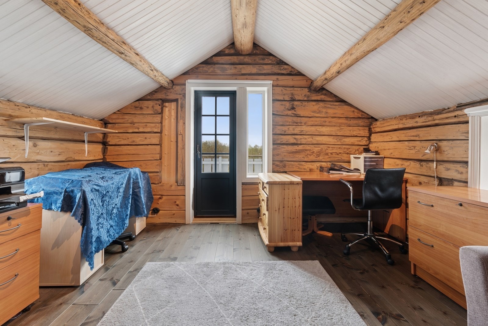 Dette soverommet har flotte tømmervegger som tilfører både varme og særpreg. Herfra har du også direkte utgang til en hyggelig balkong på ca. 2 m² - perfekt for å nyte morgenkaffen eller en stille stund i frisk luft. Se pkt. ferdigattest. Galleribilde