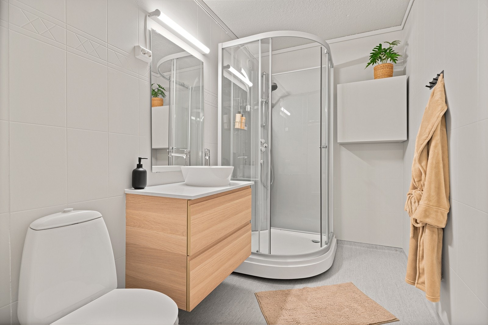 Badet har malte veggplater, dusjkabinett og ny bollevask samt servantskap med god oppbevaringsplass. Galleribilde