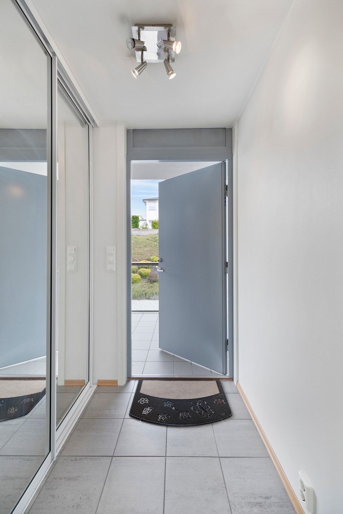 Flislagt vindfang med varmekabler i gulv og skyvedørsgarderobe. Galleribilde