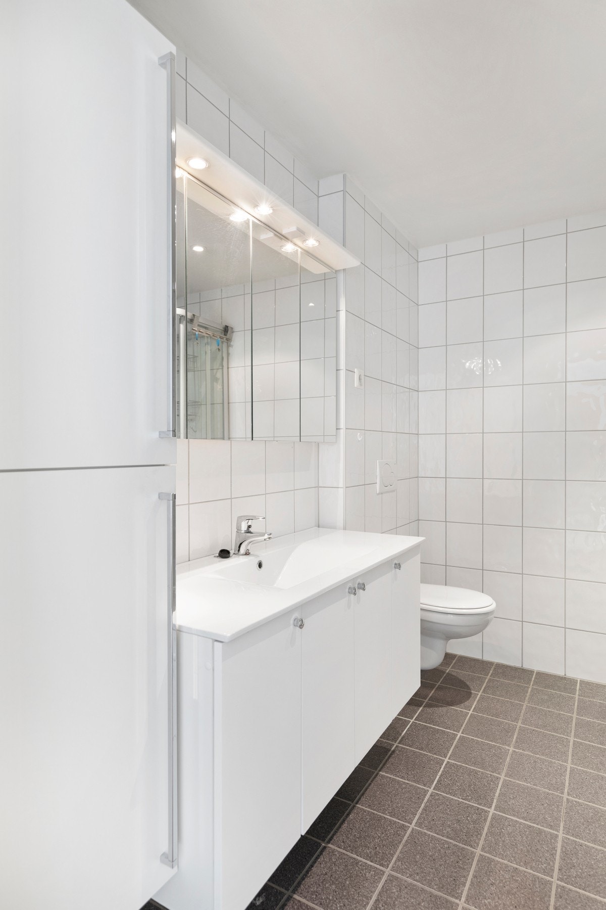 Badet er utstyrt med varmekabler i gulv, dusjkabinett, vegghengt toalett, opplegg for vaskemaskin og tørketrommel, varmtvannsbereder, samt baderomsinnredning med servant, speil og belysning. Galleribilde