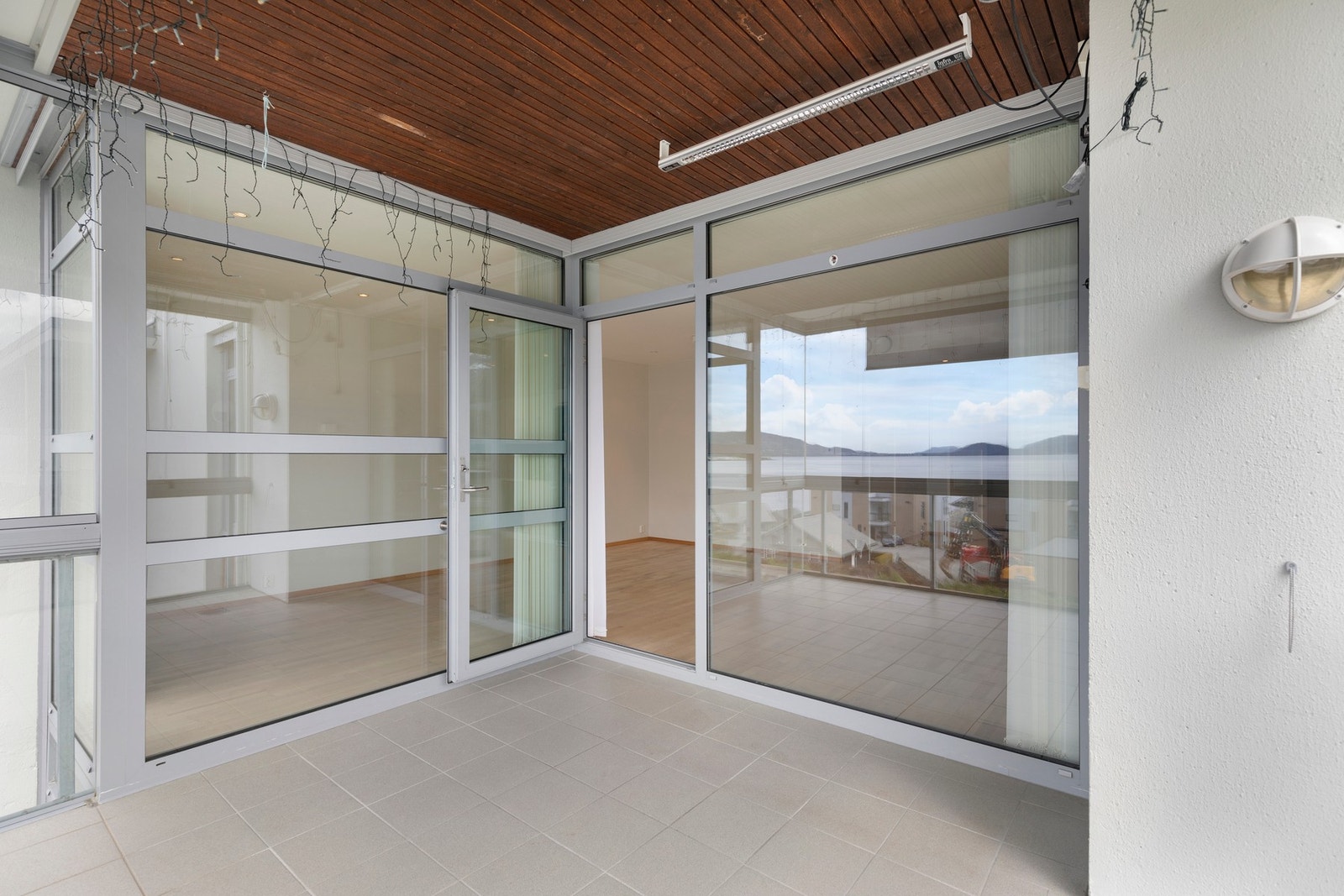 Fra stue er det utgang til innglasset balkong med flislagt dekke og strømuttak. Galleribilde