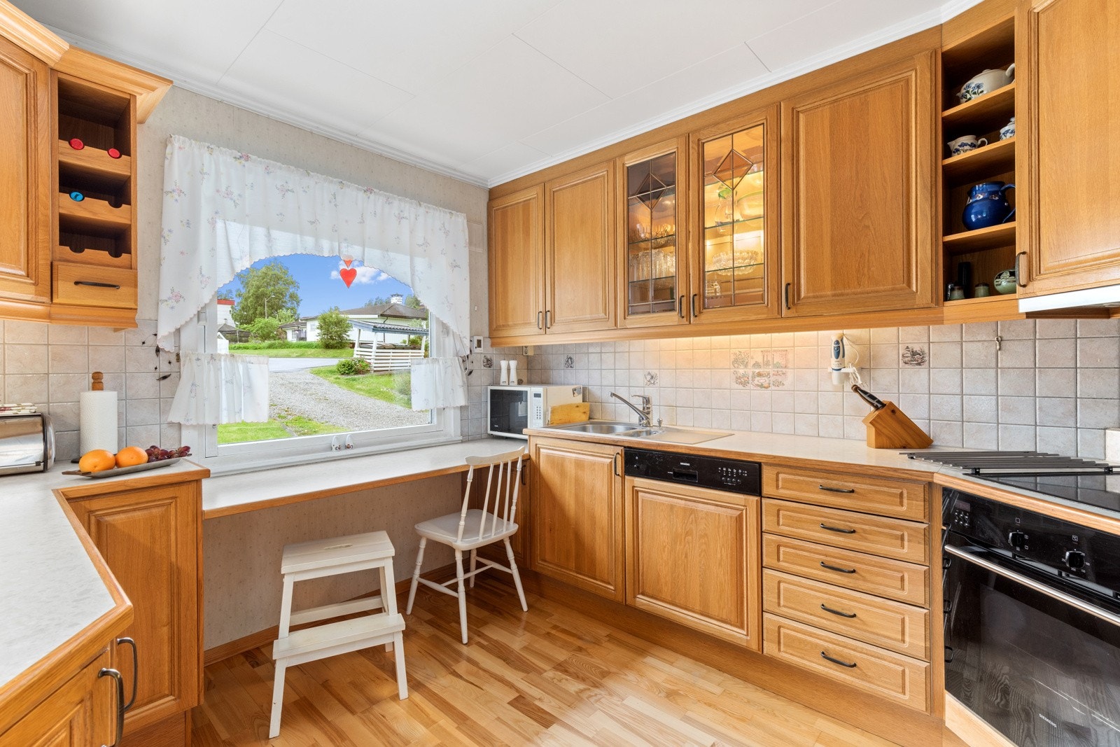 Kjøkkeninnredning med profilerte heltre fronter fra 2002. Benkeplate av laminat. Galleribilde