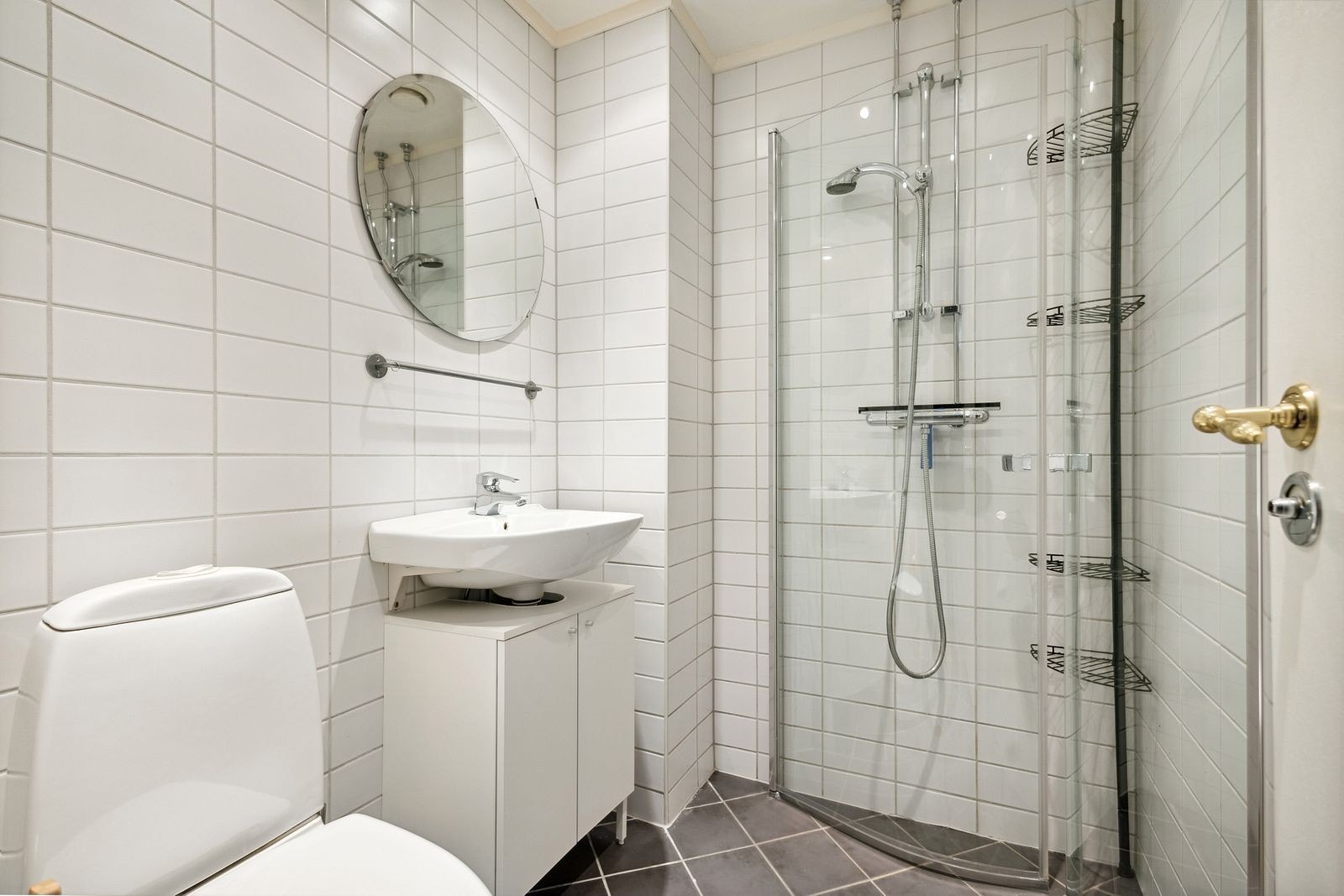 Helfliset baderom med servant, gulvmontert toalett og dusjhjørne Galleribilde