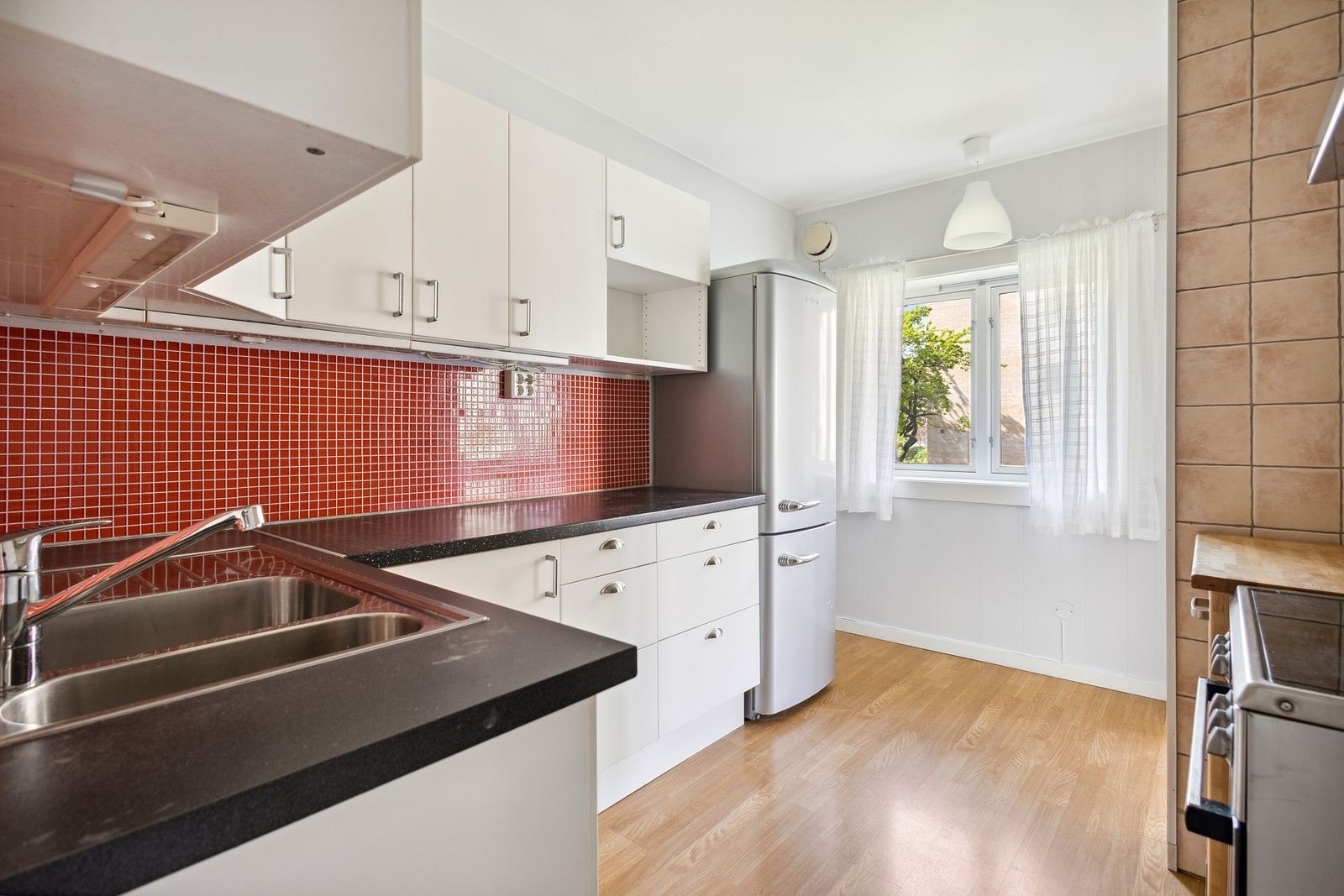 Kjøkkenet ligger delvis adskilt fra stuen og har godt med skap- og benkeplass Galleribilde