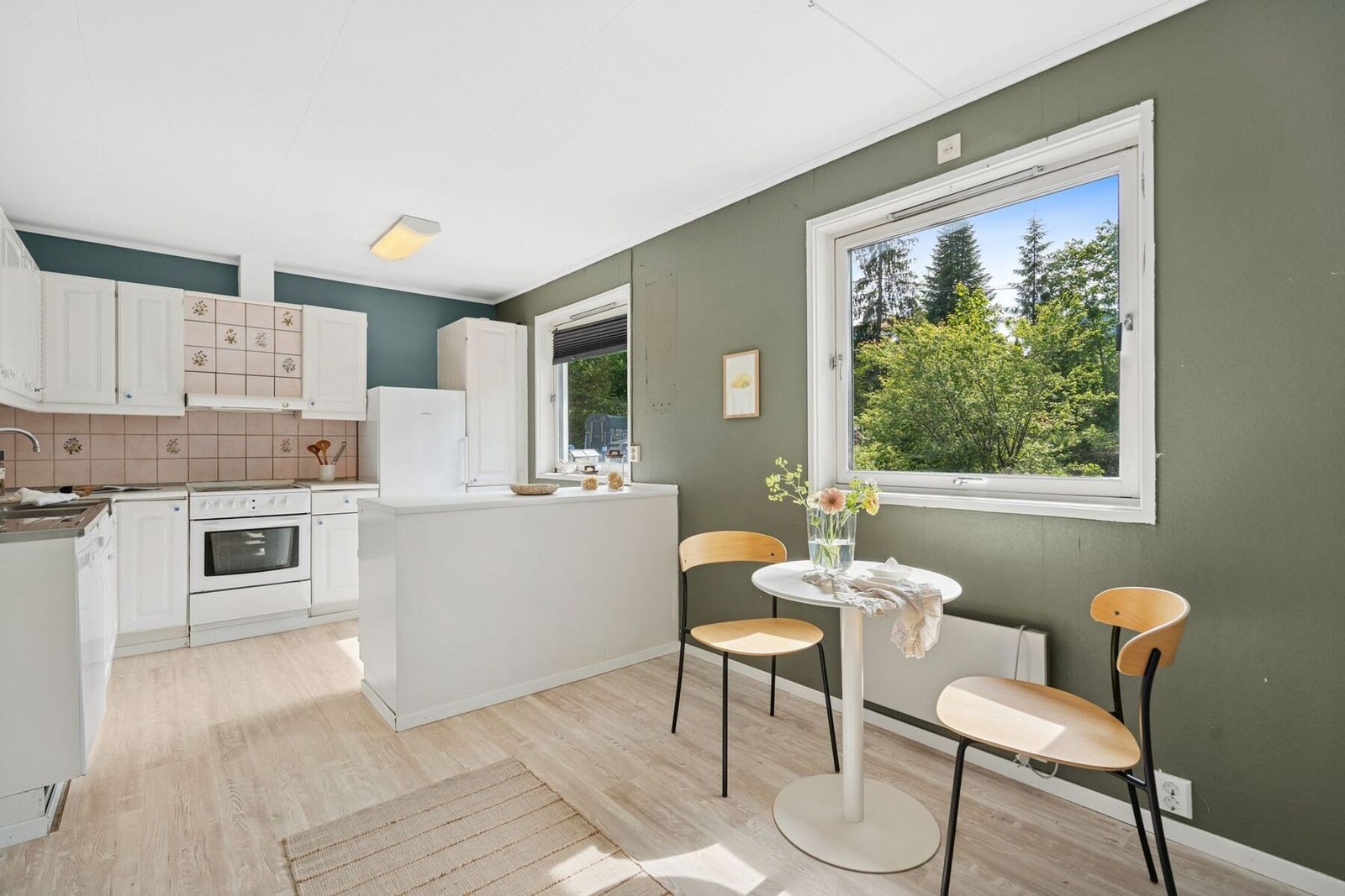 Kjøkkenet har godt med skap og benkeplass Galleribilde