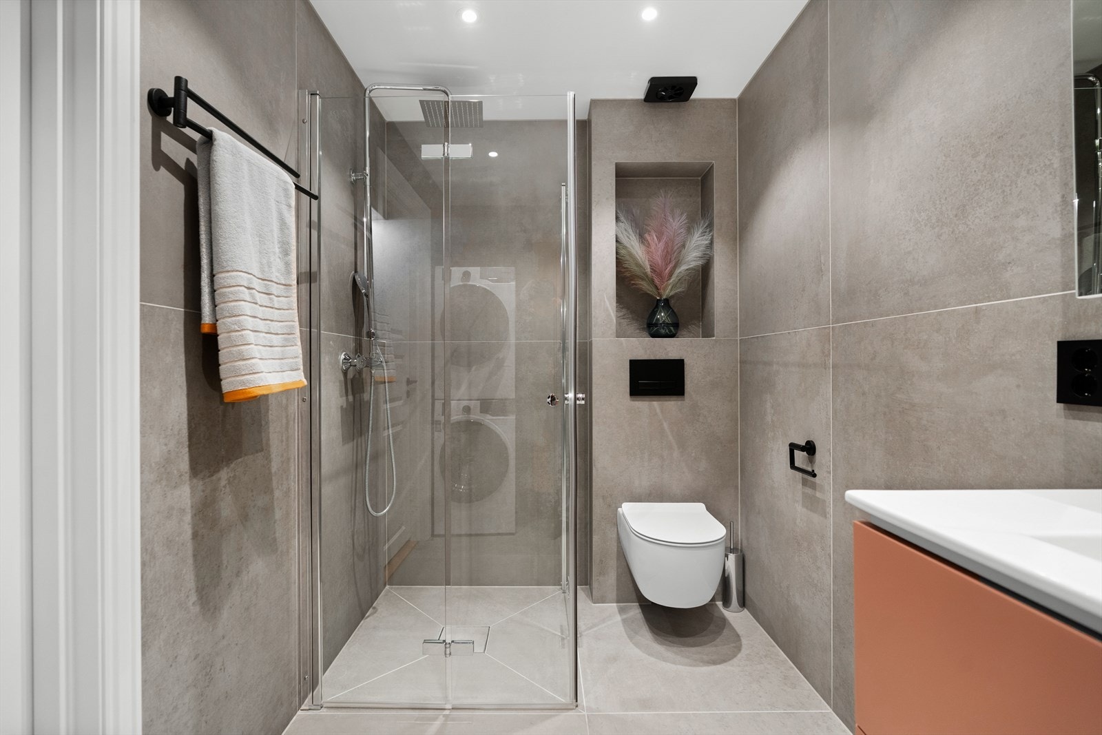 For øvrig er badet utstyrt med dusjhjørne, innfellbare glassdører, mekanisk avtrekk, opplegg for vaskemaskin/tørketrommel og veggmontert wc. Galleribilde