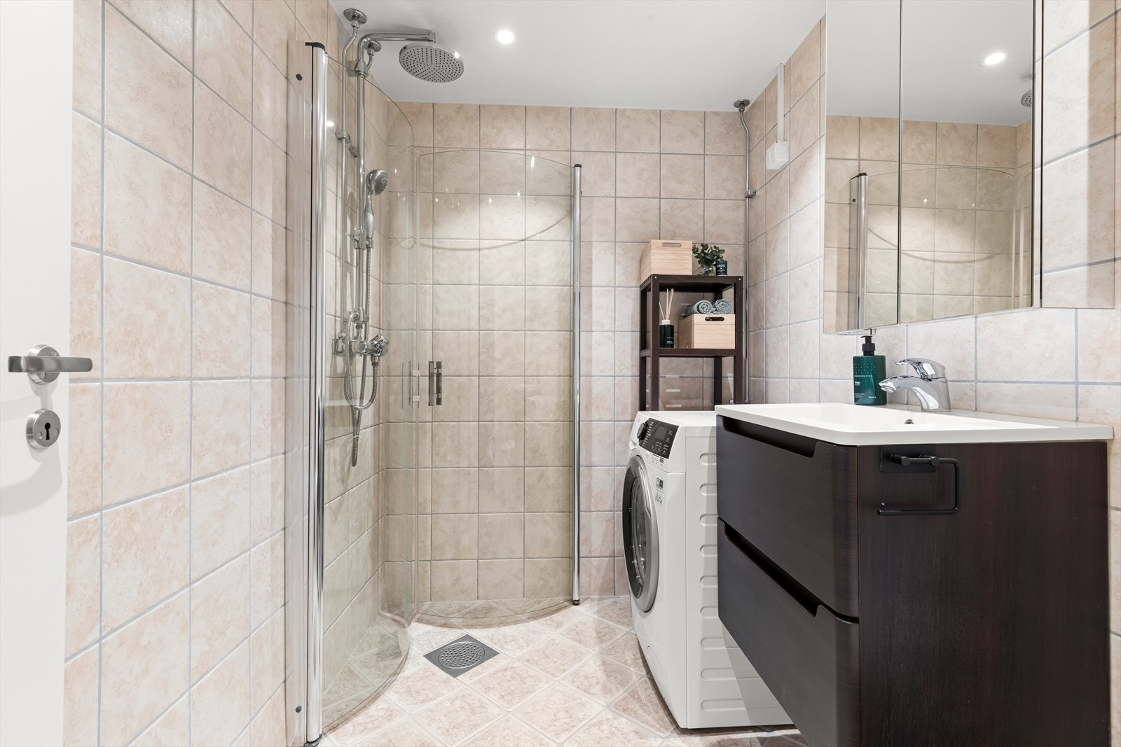 Baderomsinnredningen består av ett praktisk speilskap og heldekkende servant. Badet er videre utstyrt med dusjdører i herdet glass. Galleribilde