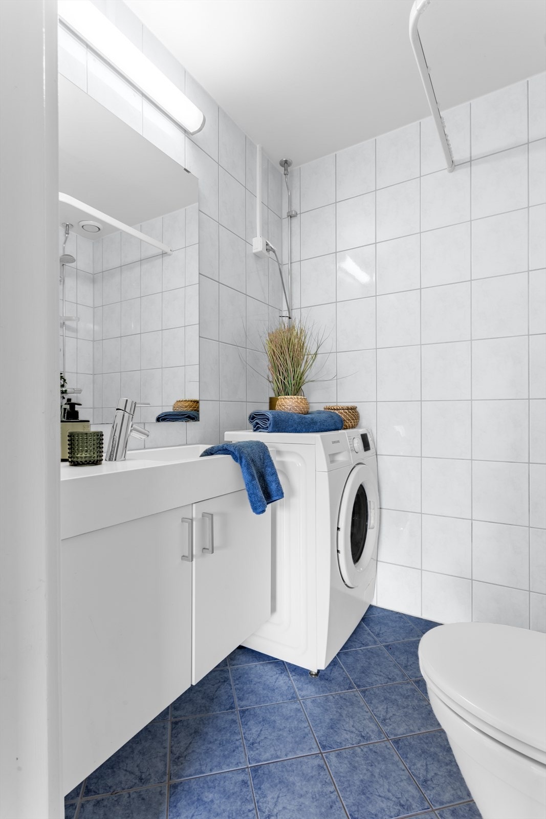 Flislagt baderom med behagelig gulvvarme og opplegg for vaskemaskin. Galleribilde