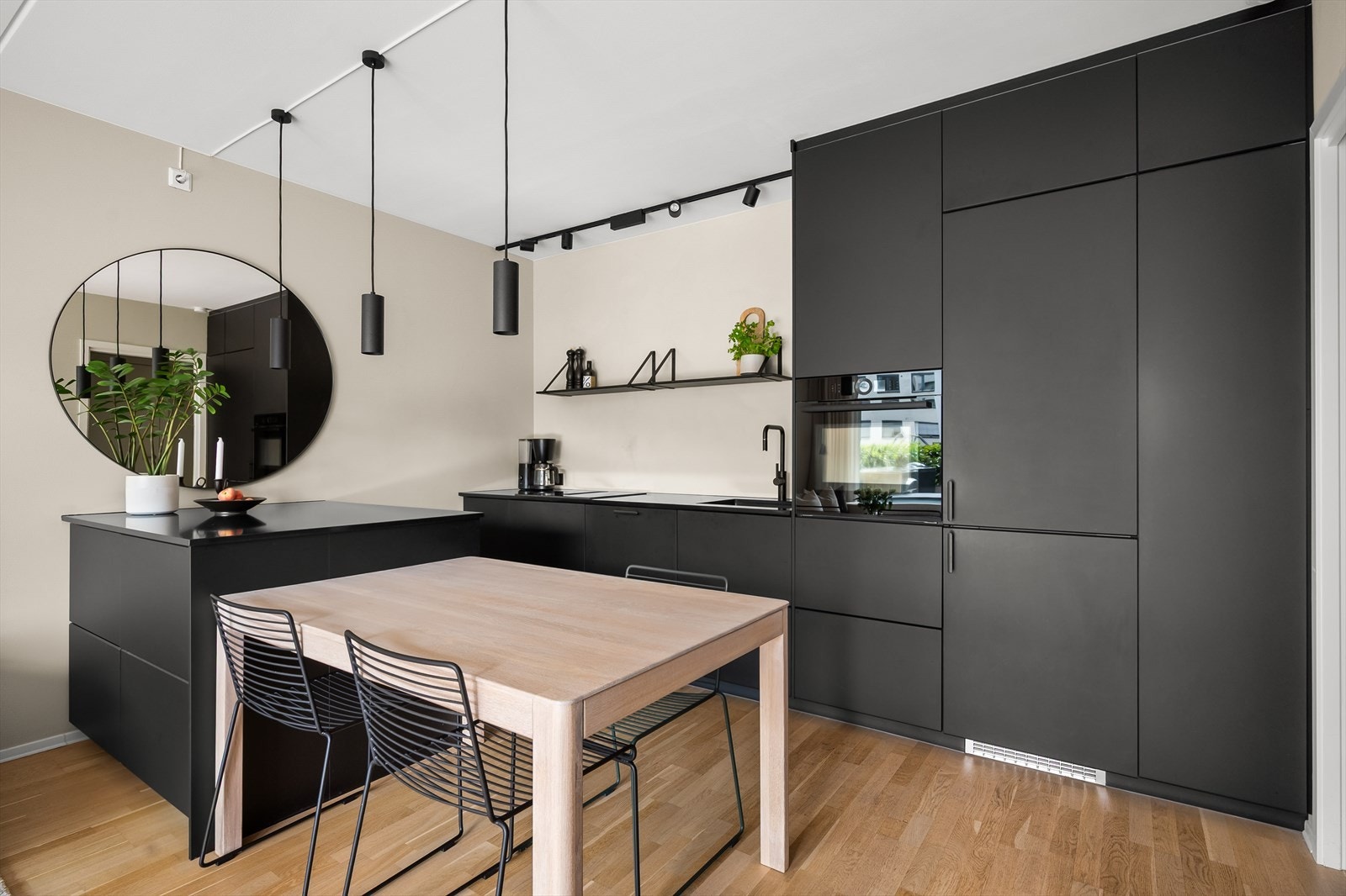 Kjøkkenet har mørke, glatte fronter og benkeplate i stein med nedfelt vask. Galleribilde