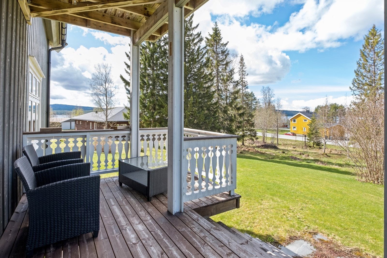 Terrasse og tomta som strekker seg helt ned til vegen. Galleribilde
