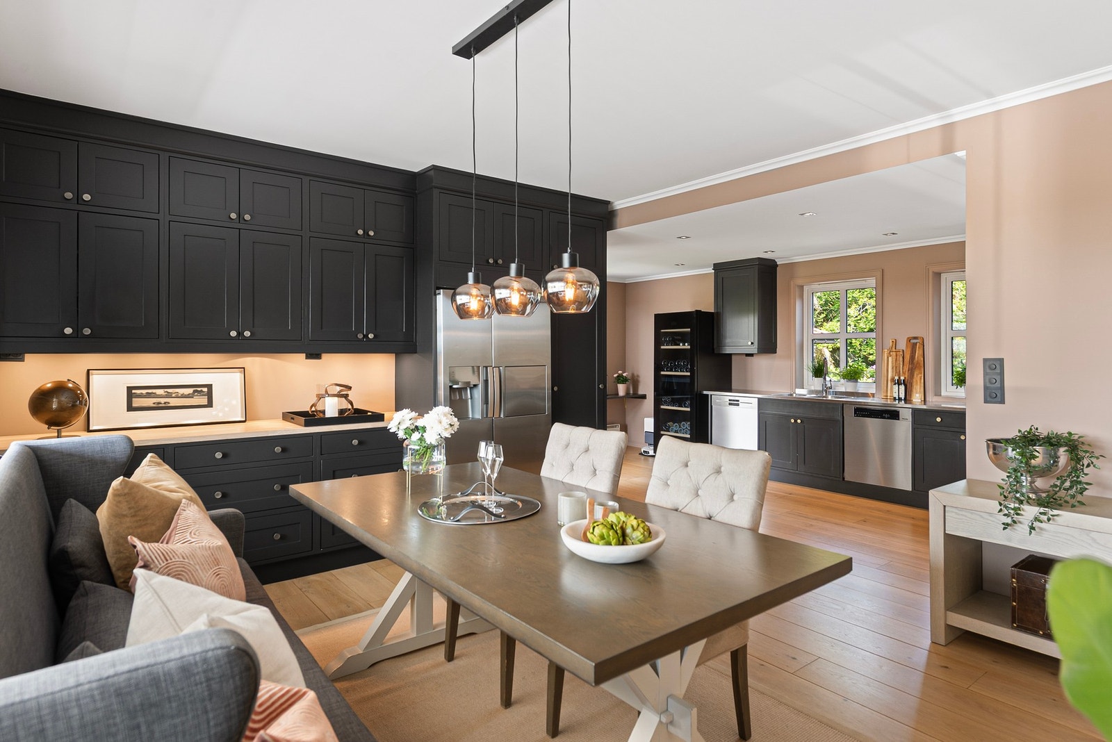 De mørke, profilerte kjøkkenfrontene skaper en stilig kontrast til det lyse rommet og understreker den gjennomførte stilen Galleribilde