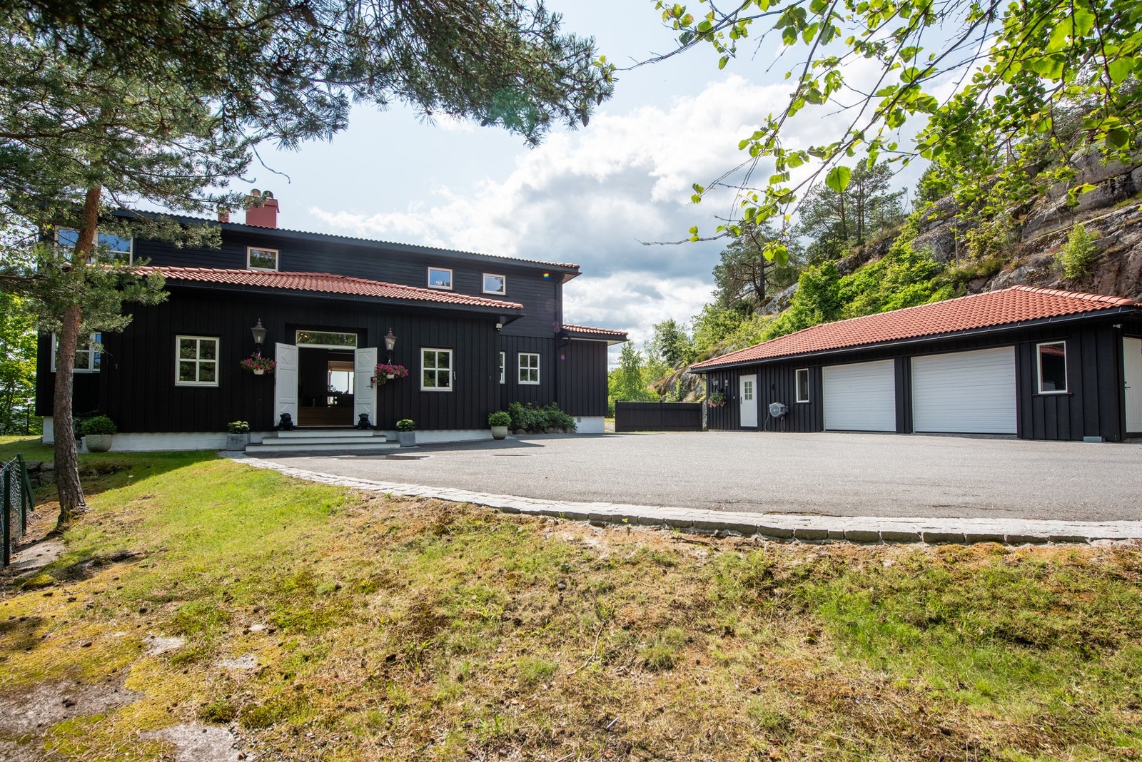 Innkjørsel og inngangsparti er helhetlig utformet og matcher villaens stil - et innbydende førsteinntrykk Galleribilde