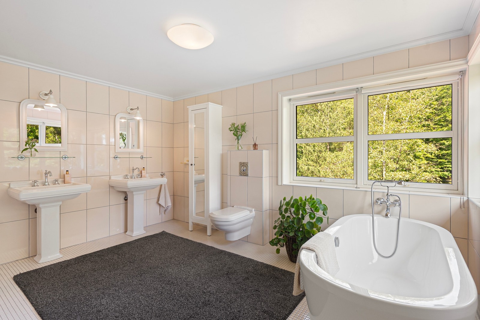 I tråd med den herskapelige stilen finner du to porselenservanter, lune fliser, et innbydende badekar og flotte vindusflater som slipper inn rikelig med naturlig lys Galleribilde