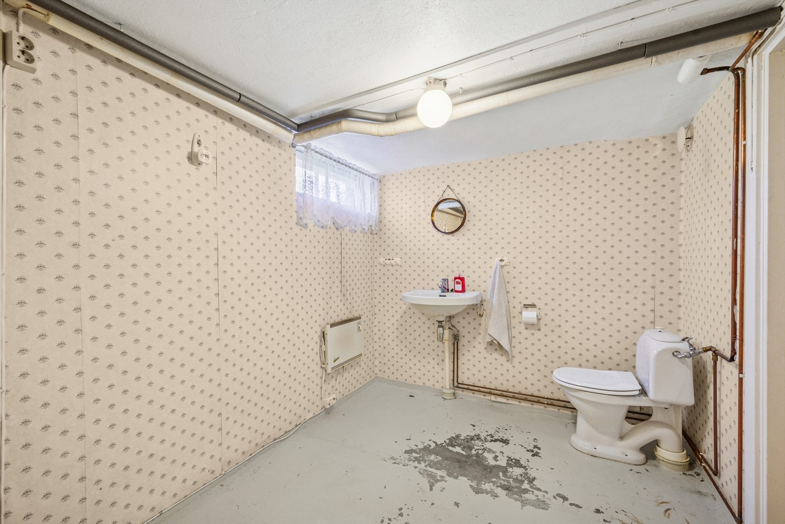 Toalettrom i kjeller har servant og gulvstående klosett. Galleribilde