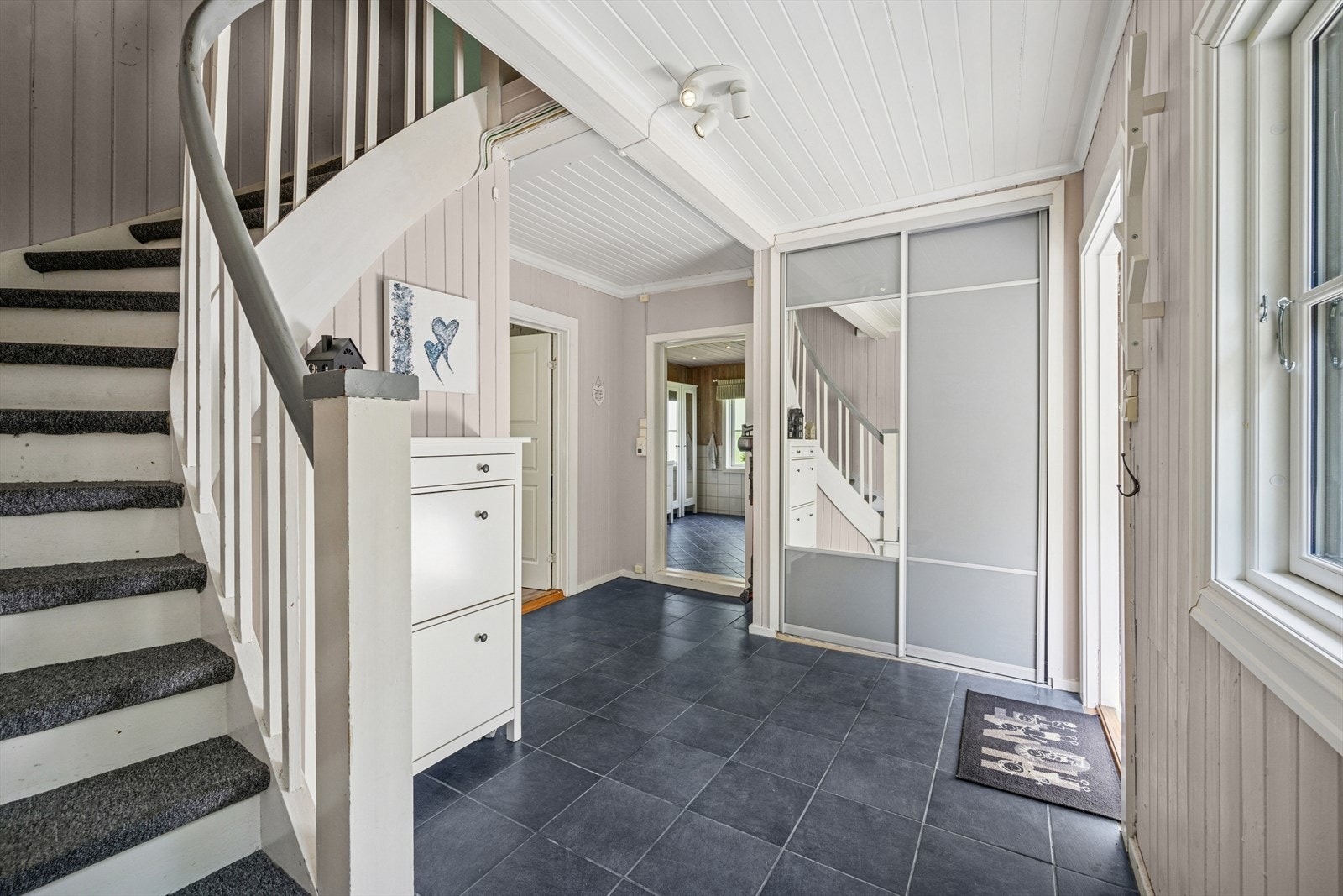 Man blir ønsket velkommen inn i en romslig gang med praktiske fliser og god garderobeplass til yttertøyet. Galleribilde