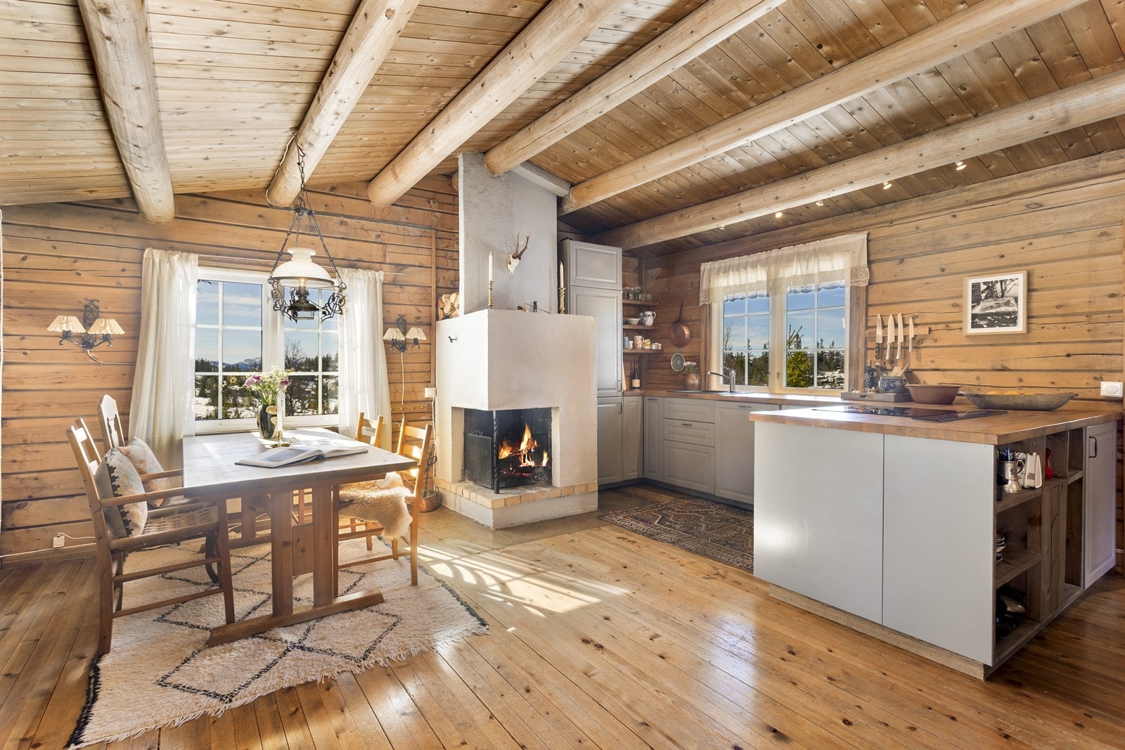 Kjøkkenet byr på en praktisk utforming i åpen løsning mot spisestue og stue, lyse profilerte fronter og benkeplate i heltre. Galleribilde