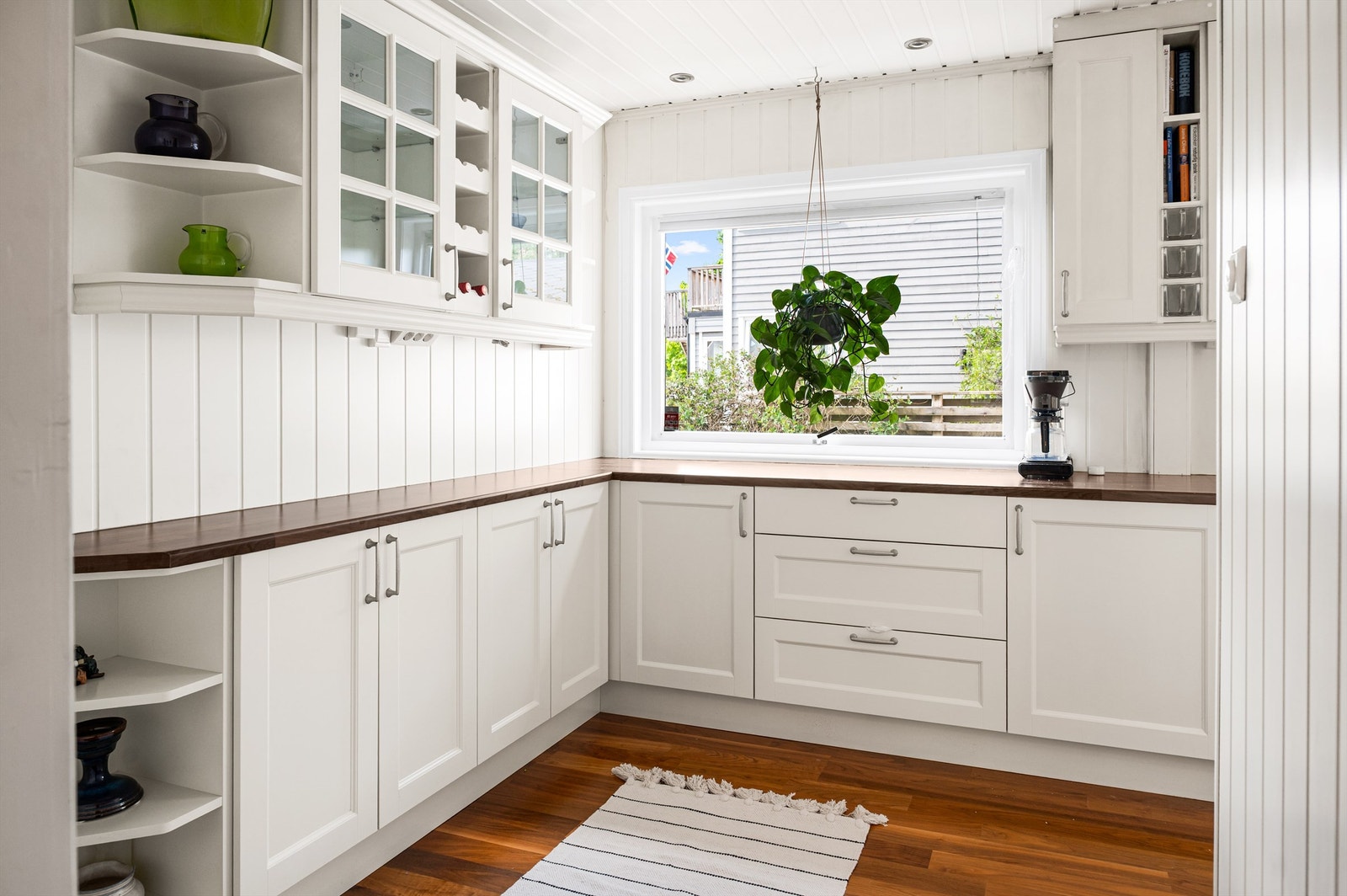 Over benkeplaten er det splashboard og belysning. Hvitevarene er sømløst integrert i innredningen og består av kjøl-fryseskap, stekeovn, induksjonstopp, oppvaskmaskin og kombinert micro/stekeovn. Galleribilde