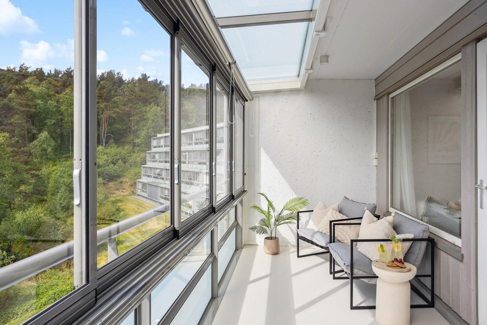 Balkongen har store vindusflater som slipper inn rikelig med dagslys og skaper en lys, luftig og innbydende atmosfære Galleribilde