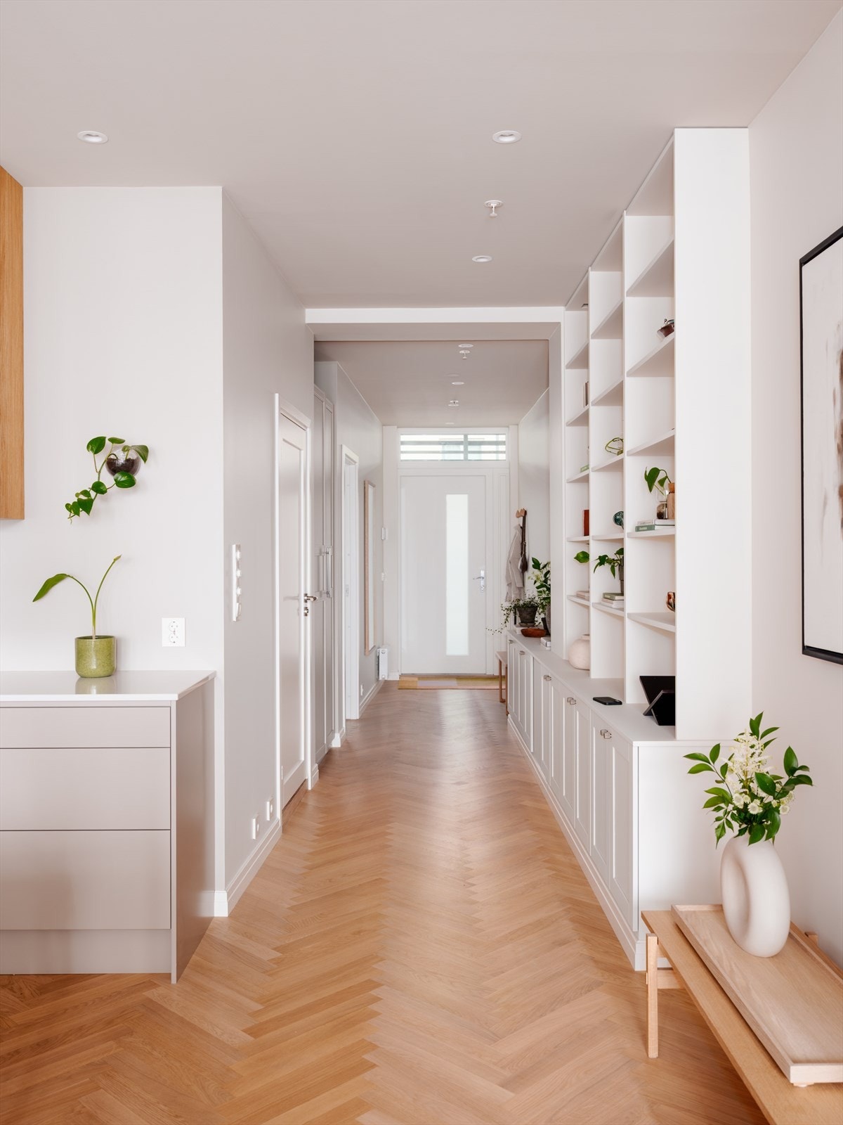 Det er en vakker, plassbygget bokhylle som strekker seg fra entréen og ut til stue, med masse lagringsplass. Galleribilde