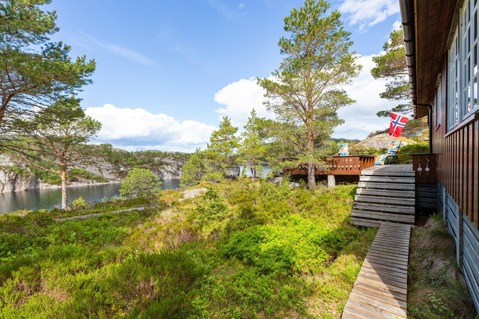 Pent opparbeidet naturtomt på 988,5 kvm med trapper og stier bygget i treverk og terrasse på terreng. Galleribilde