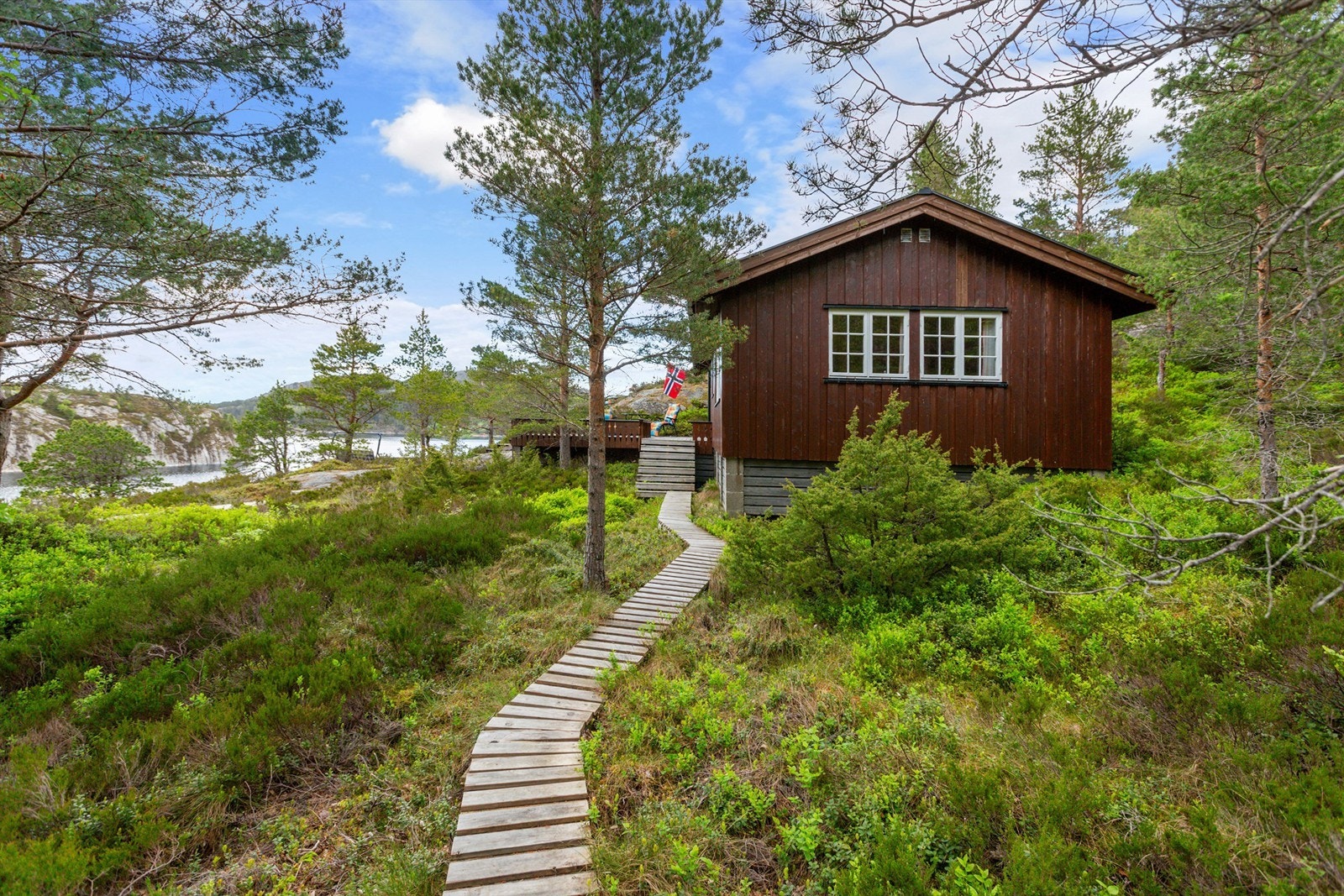 Det medfølger parkeringsplass på felles parkeringsplass ved brønnhuset. Mellom parkeringsplassen, hytta og naustet er det opparbeidet stier av treverk. Galleribilde