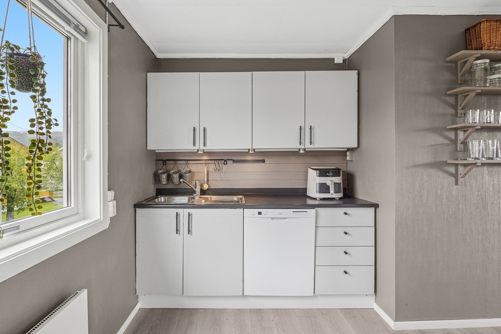 Kjøkkenet er lyst og tidløst. Innredning med hvite slette fronter og benkeplate av typen laminat. Galleribilde