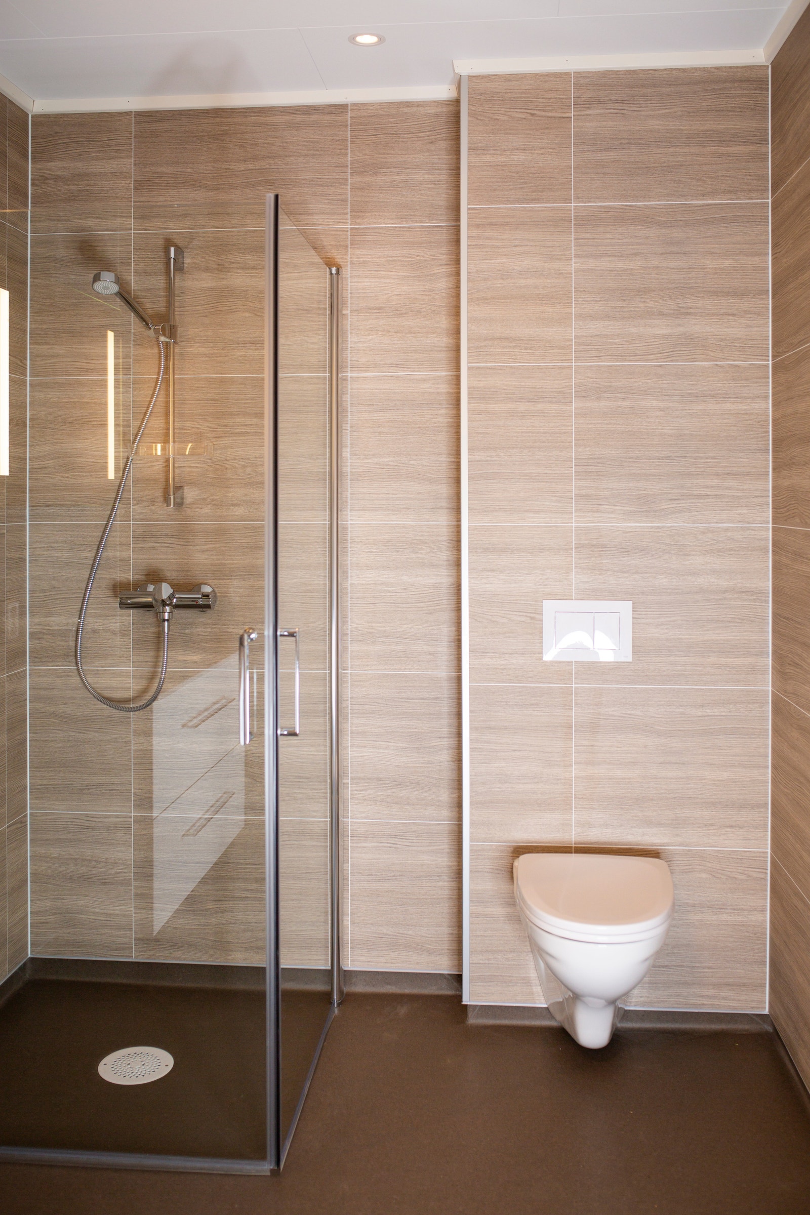 Moderne bad med dusjhjørne og vaskemaskin – funksjonelt og delikat. Galleribilde