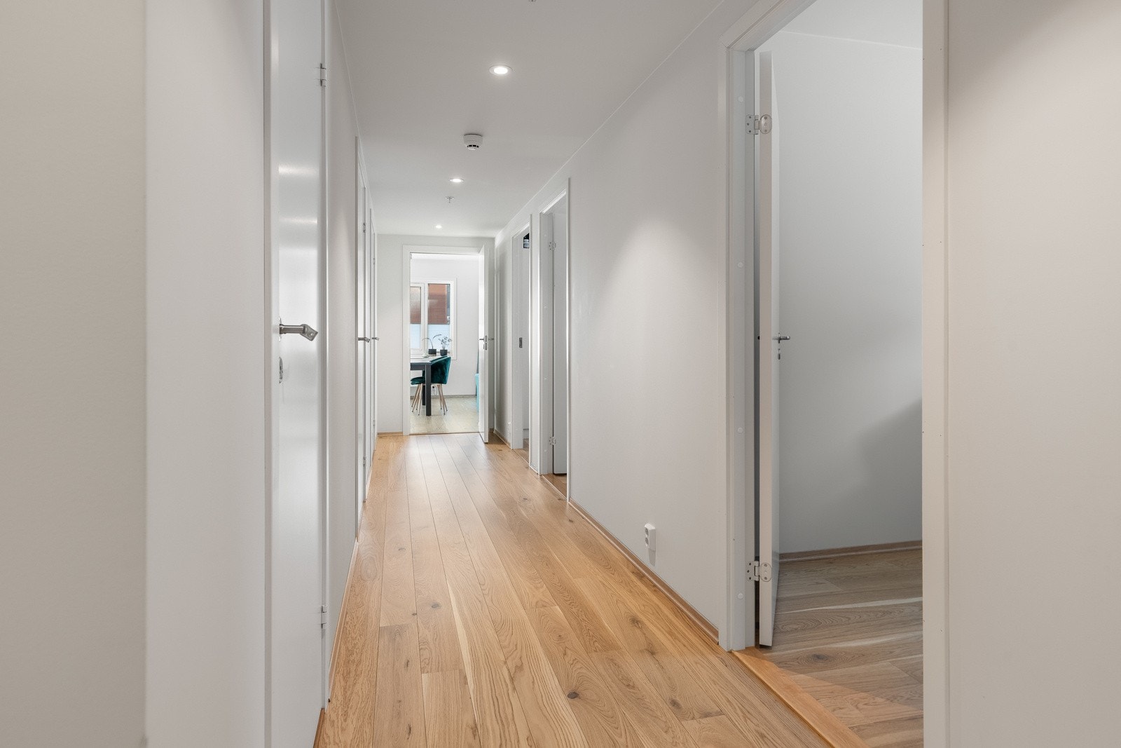 Romslig gang med downlights og fine veggflater med plass til kunst og ønsket inventar. Mellom baderommene er det egen bod/teknisk rom. Galleribilde