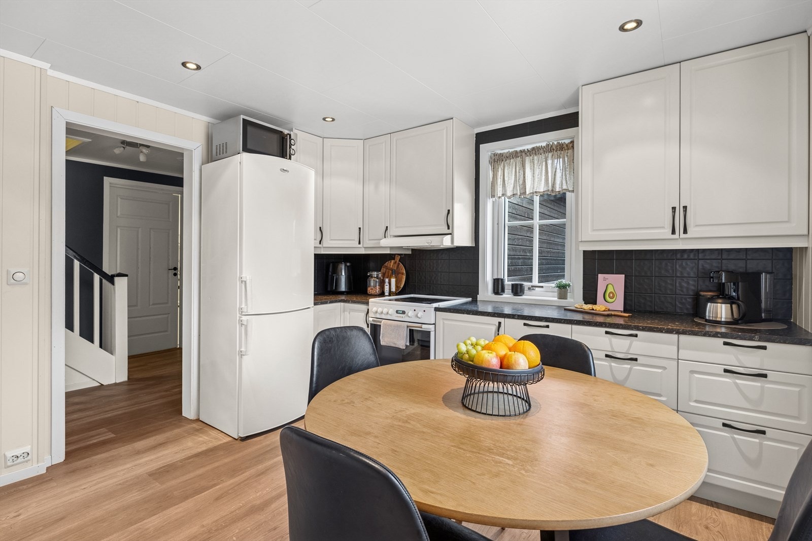 Kjøkkenet har adkomst fra spisestuen, her finner du en hvit innredning med profilerte fronter og laminert benkeplate. Galleribilde