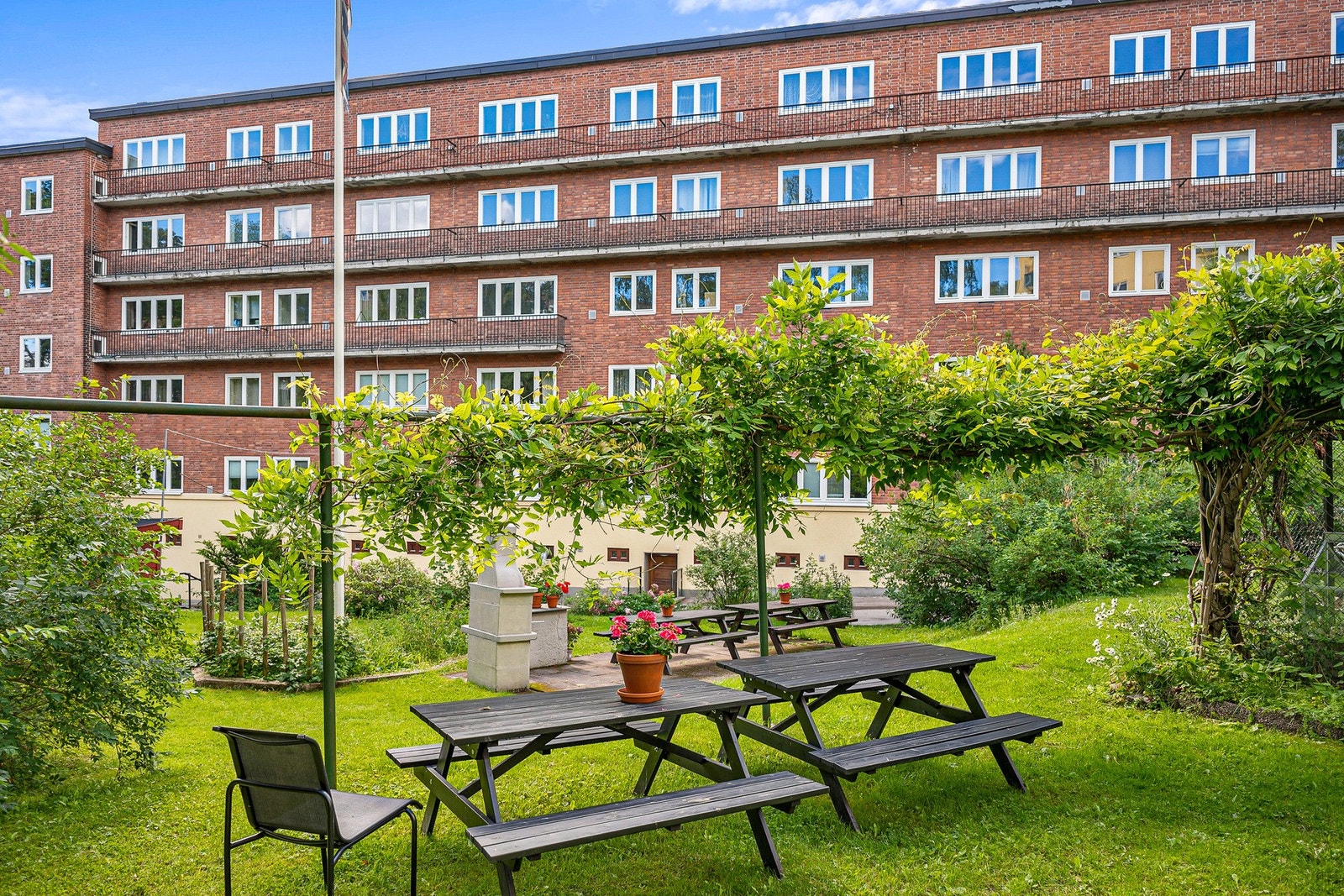 Pent opparbeidede fellesarealer med sittegrupper, beplantning, asfalterte veier, gressplen, m.m. Galleribilde