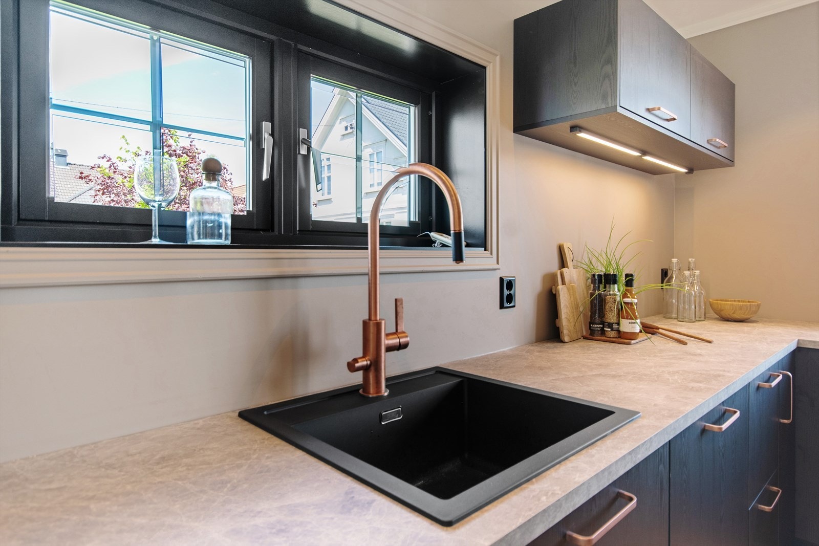 Lekker laminert benkeplate med nedfelt kum i sort utførelse med moderne blandebatteri i kobber. Galleribilde